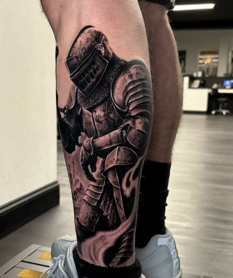 Black and gray realistic tattoo of a Star Wars stormtrooper helmet and armor on a person's leg.