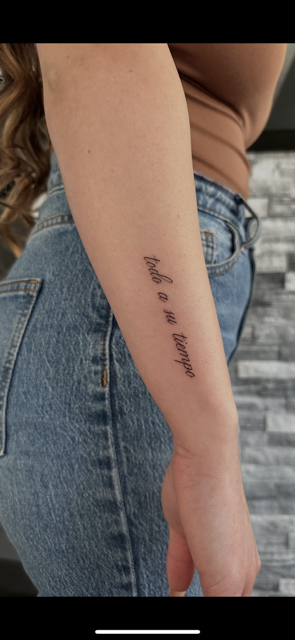 A person's forearm with a tattoo of handwritten-style text that reads 'find me in the game'.