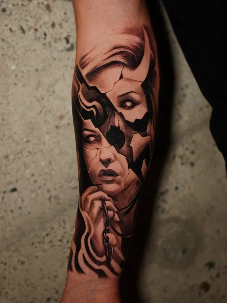 Black and gray tattoo of a woman's face with cracked, broken parts on her face, holding a chain in her hand.