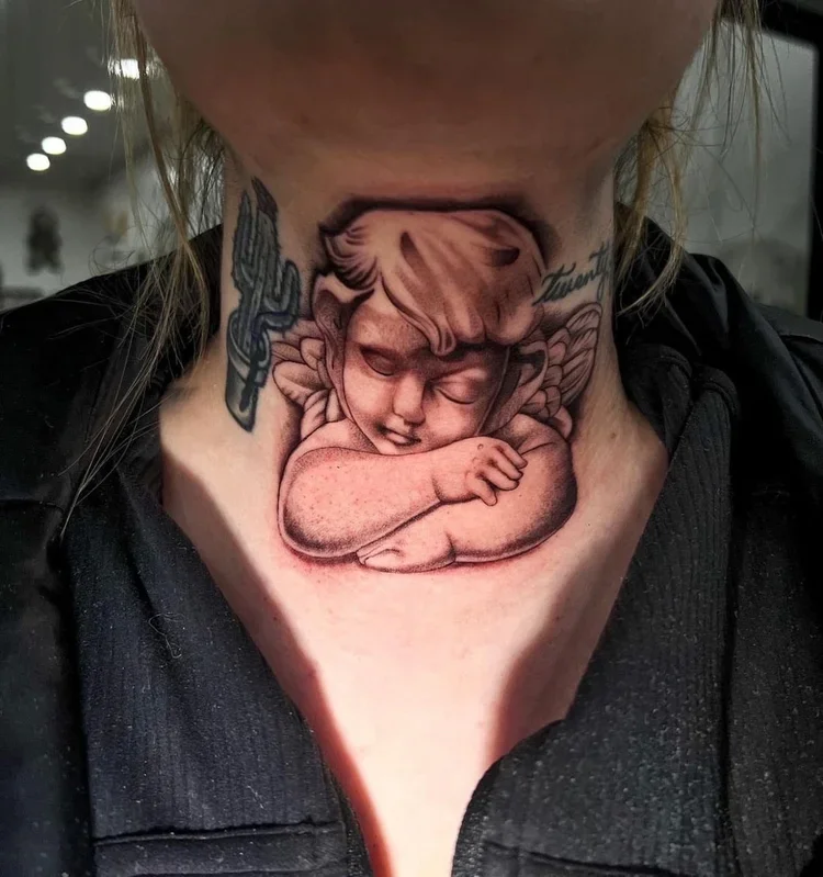 Tattoo of a sleeping angel with arms crossed on a person's neck.