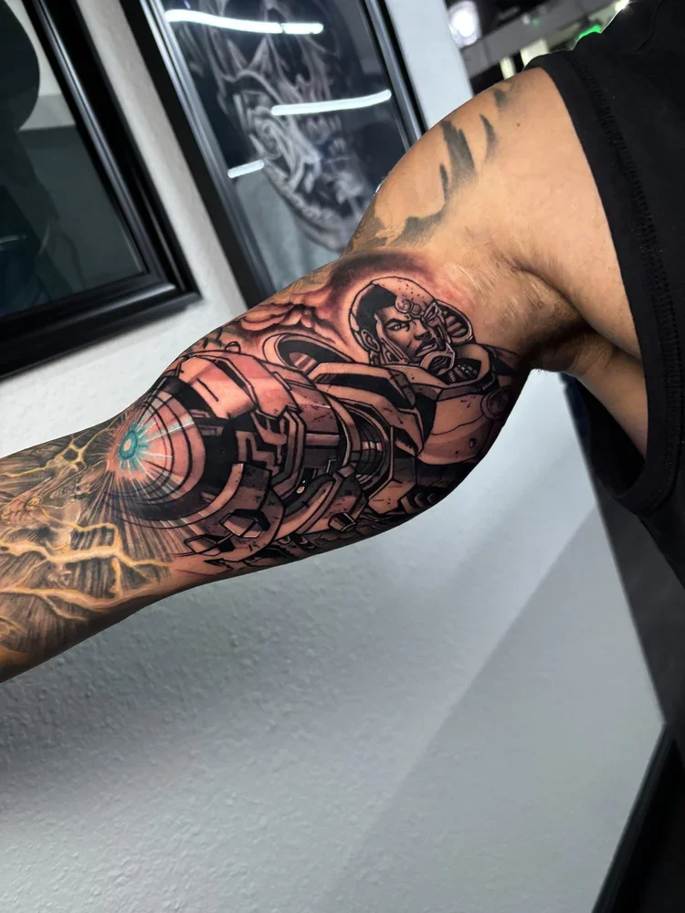 Tattoo of a woman with mechanical and futuristic elements on a person's upper arm.