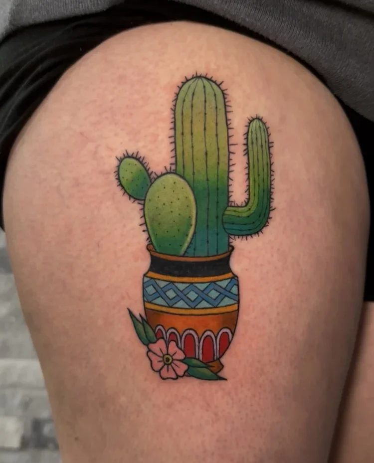 Colorful cactus and flower tattoo on skin.