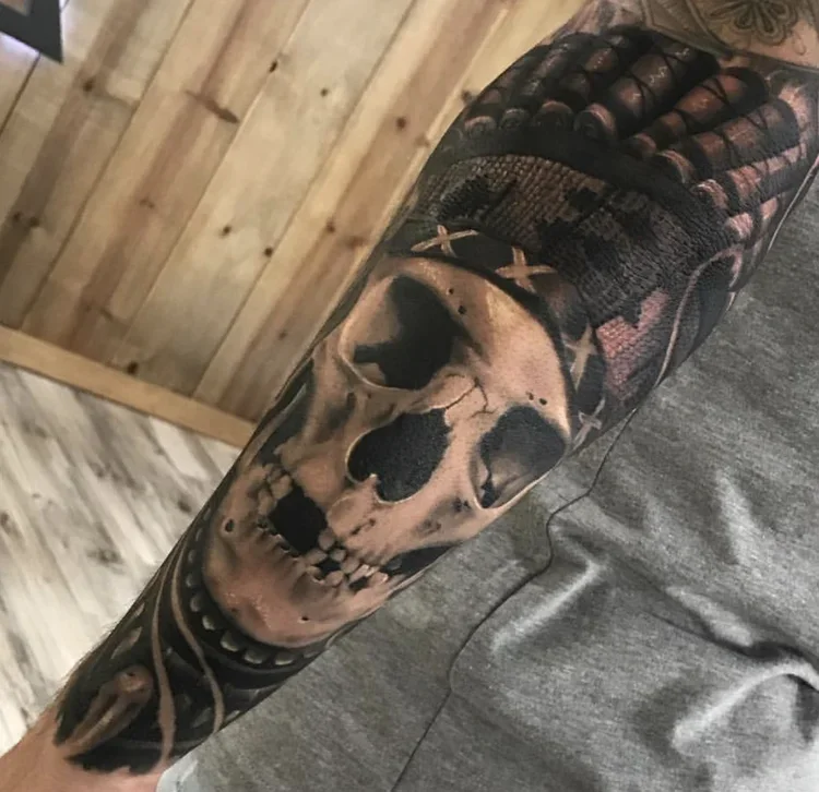 Tattoo of a realistic human skull on a person's arm.