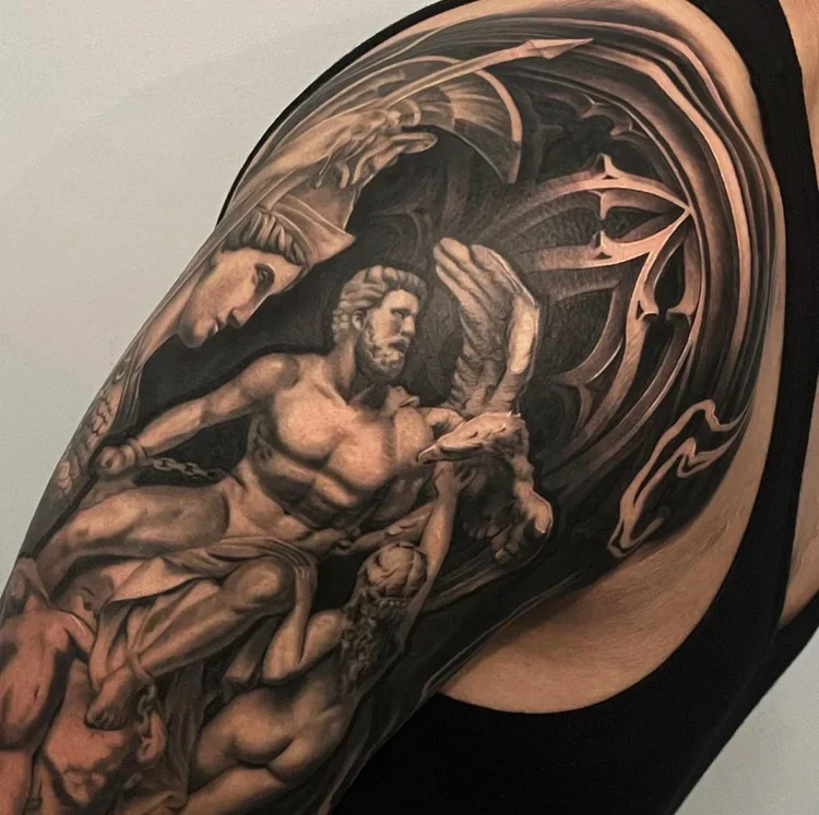 Close-up of a tattoo sleeve featuring classical-style sculptures of male figures, with detailed shading and abstract swirling background.