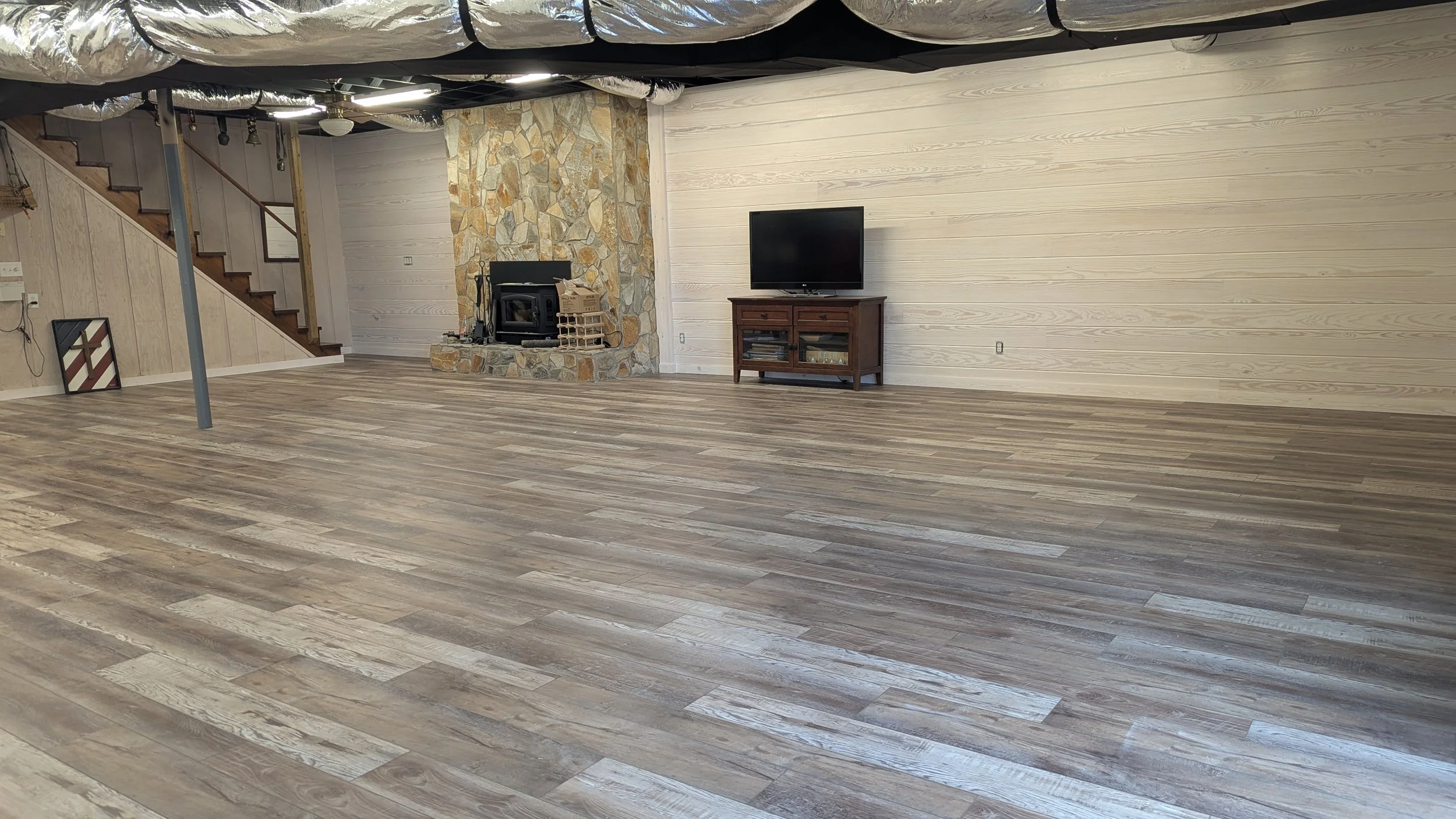 Basement conversion, Luxury Vinyl Planks, 8" Tongue and Groove Pine Board Walls, Stained.