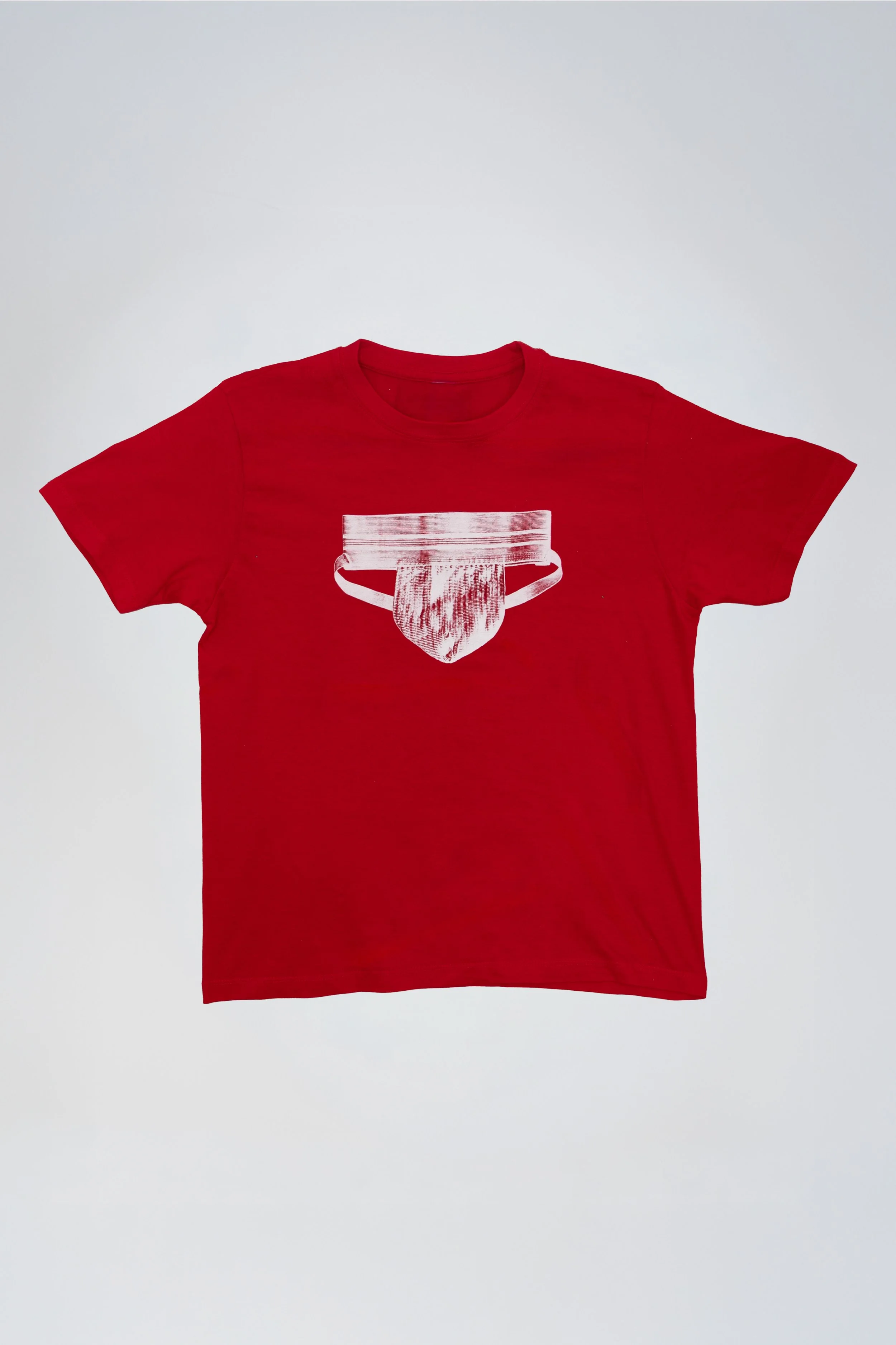 Red T-shirt with white graphic of a helmet and a tongue across the chest, laid flat on a white background.