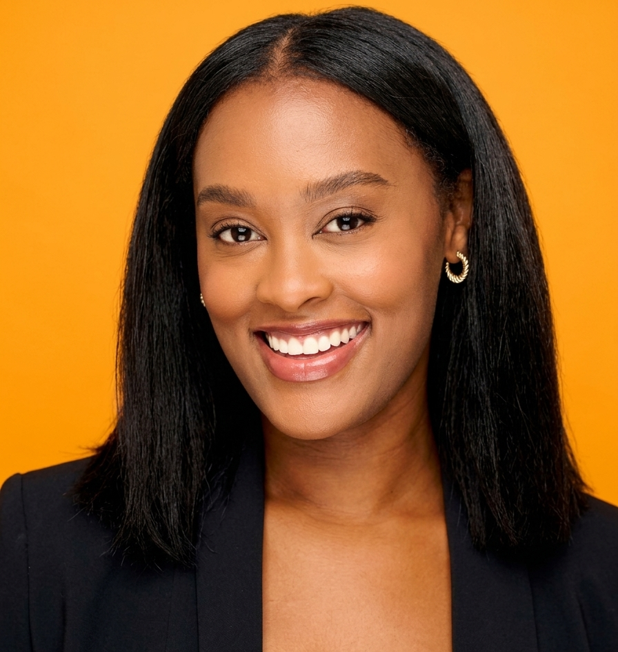 A young Black woman with shoulder-length straight hair, smiling, wearing a black blazer and gold earrings, with a bright orange background.