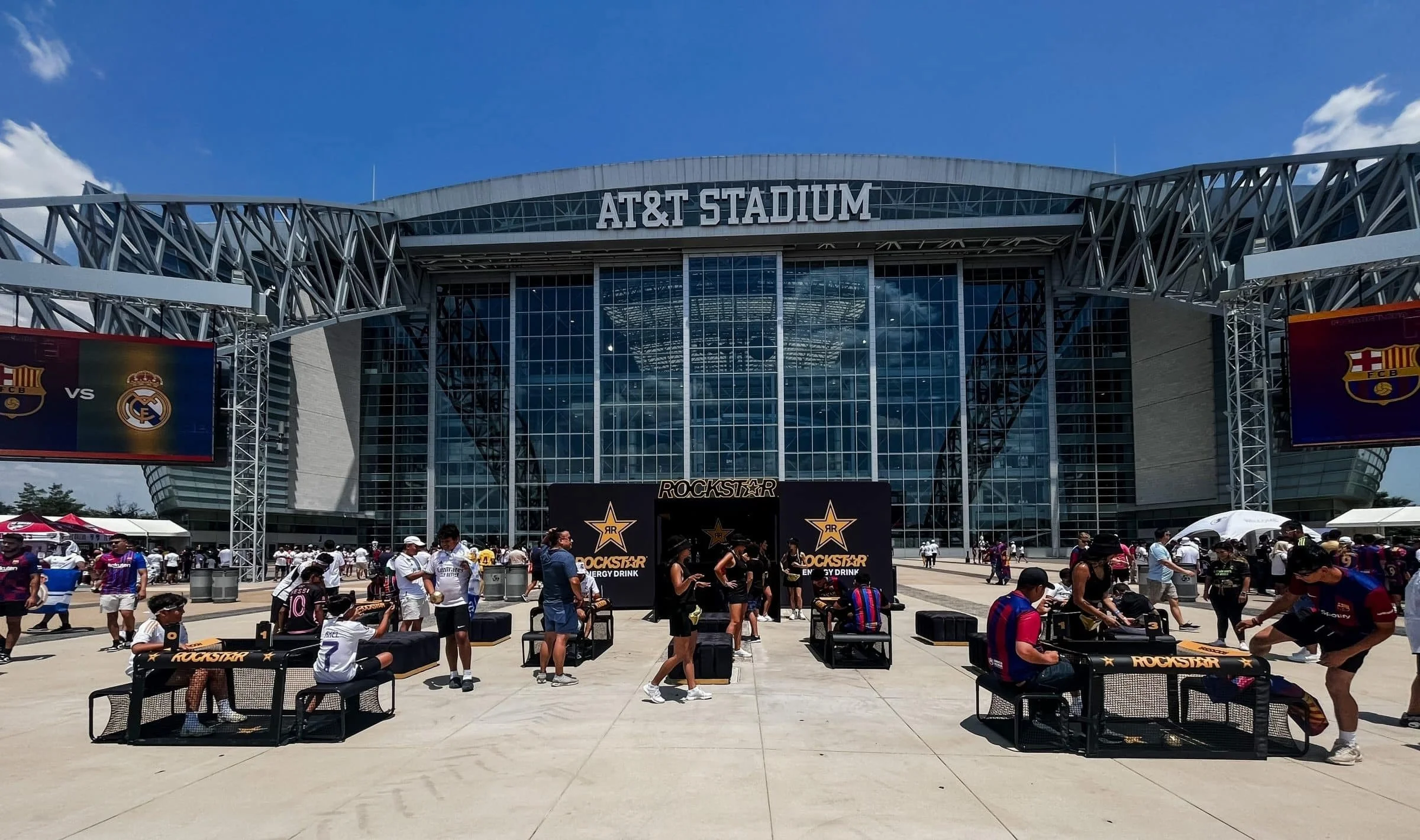 Wide exterior view of AT&T Stadium under a clear blue sky.