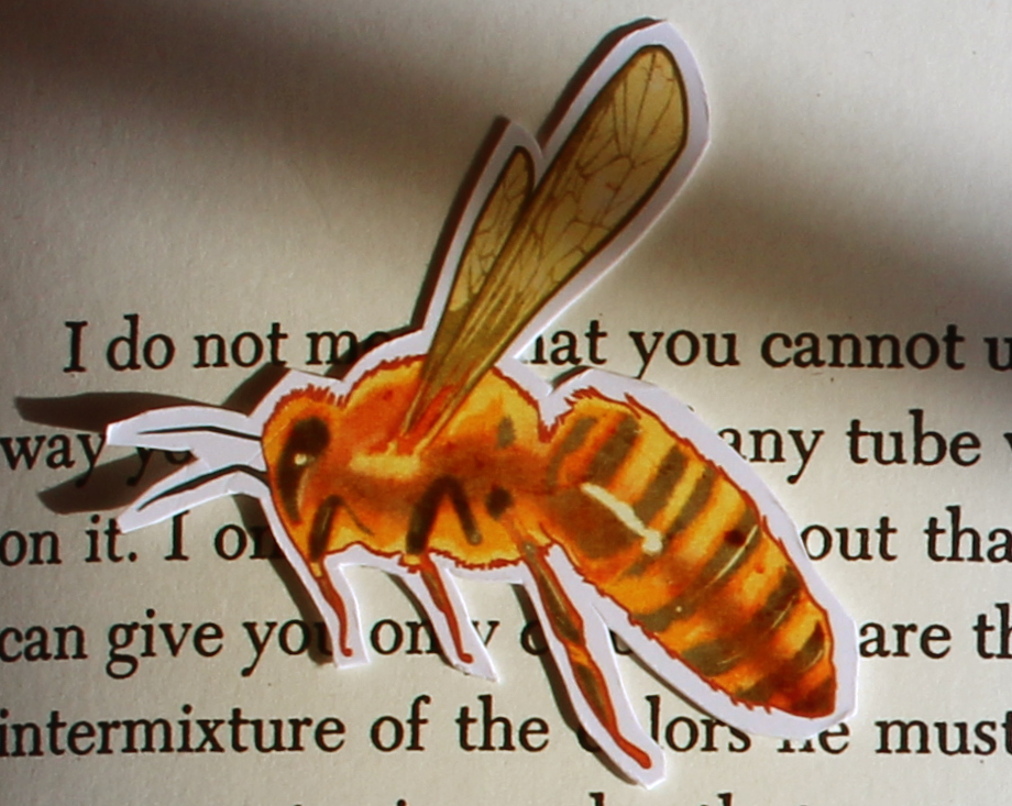 Sticker of a honey bee on a book page.