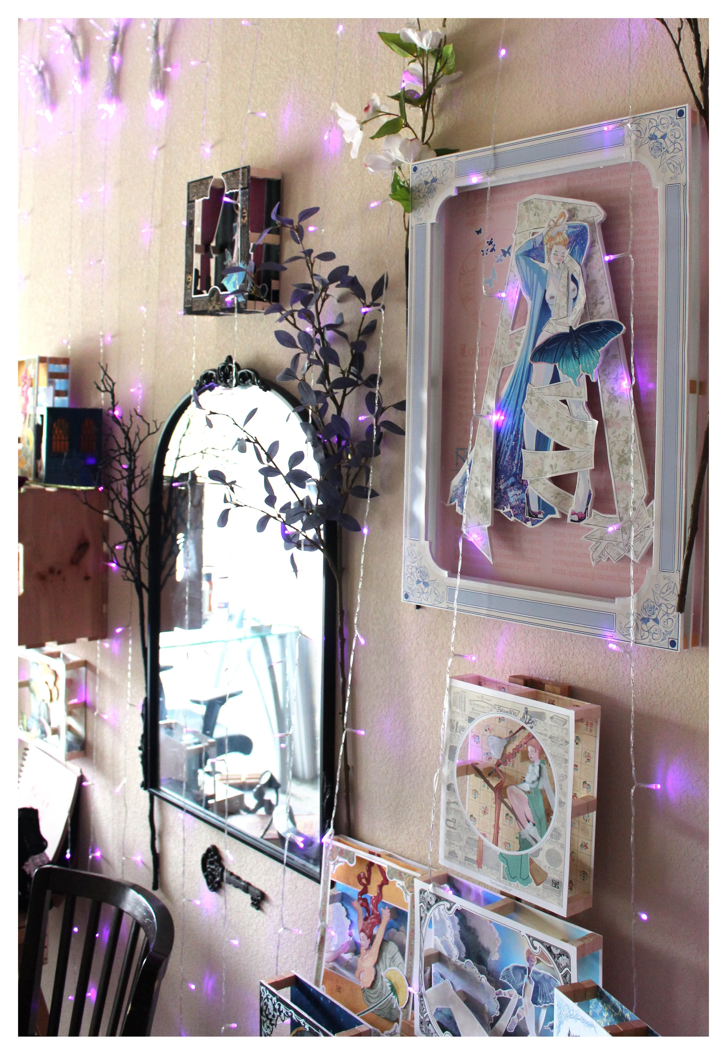 A room decorated with string lights, artificial flowers, and anime posters. A mirror is mounted on the wall, reflecting part of the room, and there is a black chair in the foreground.