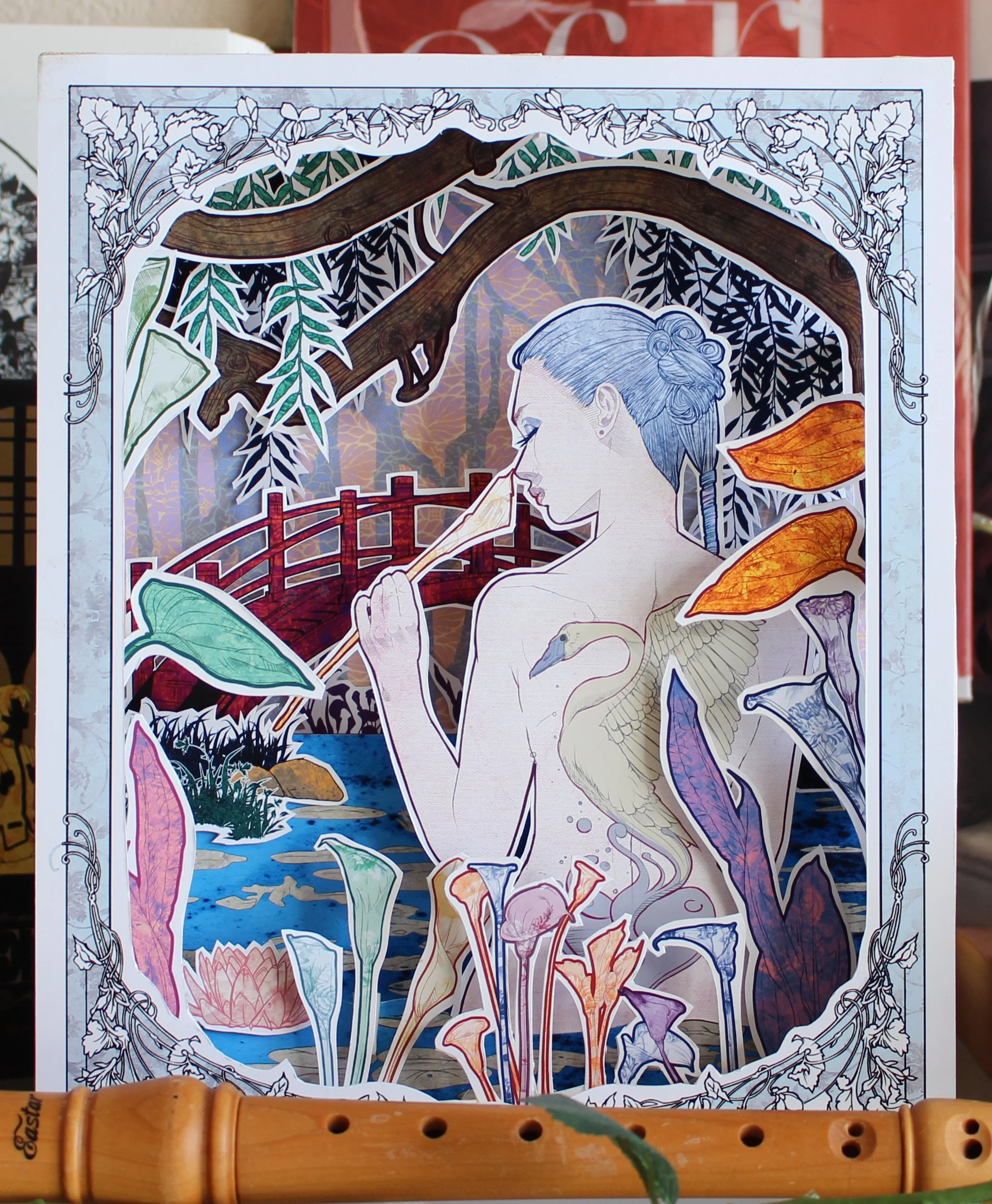 Colorful cutout artwork featuring a woman with blue hair, surrounded by various botanical elements and animals, including a duck and swan, with a nature scene in the background.
