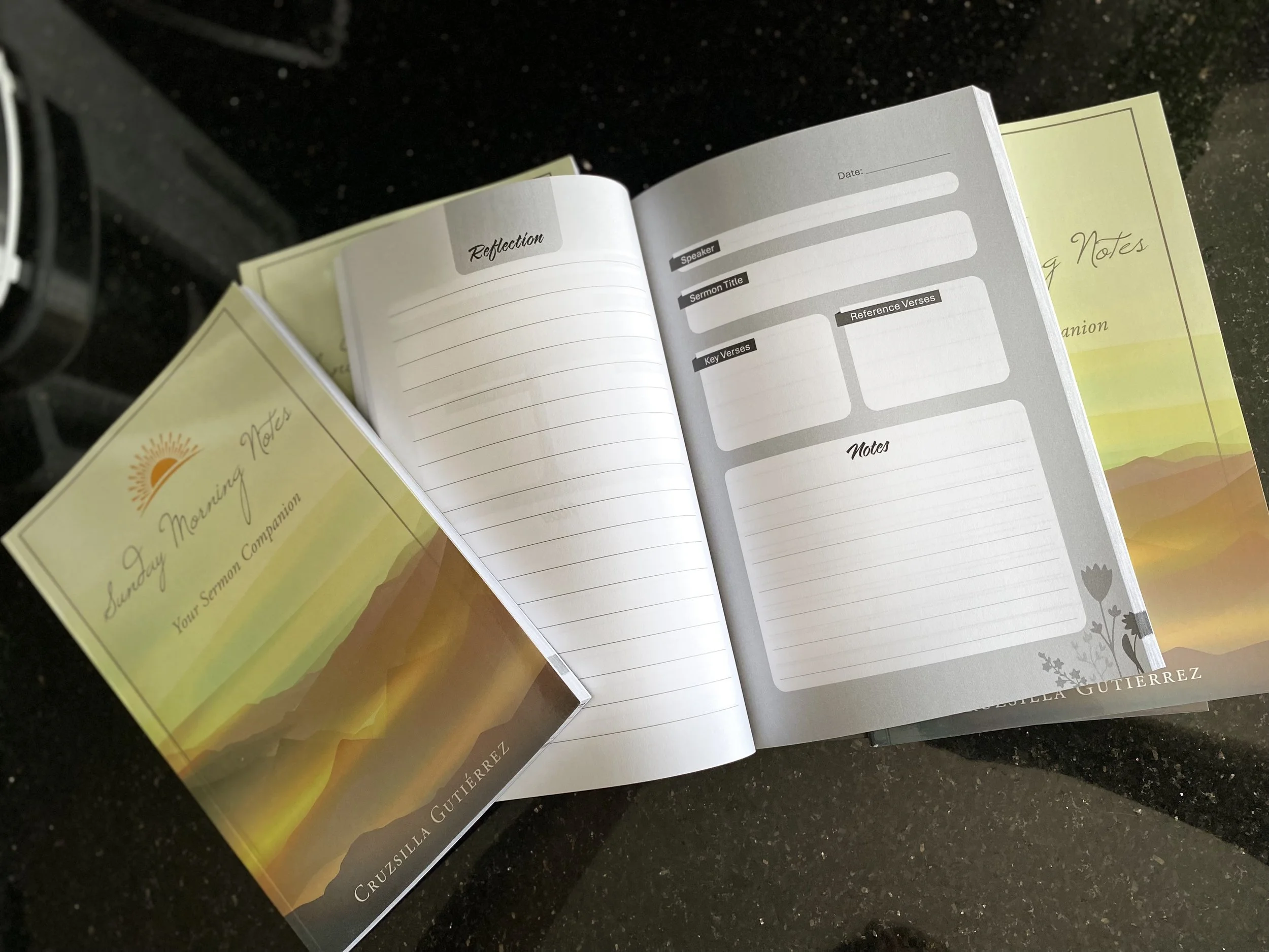 Open notebook with sections for reflections, speaker, sermon title, key verses, reference verses, and notes resting on a black speckled countertop, with yellow and white notes nearby.