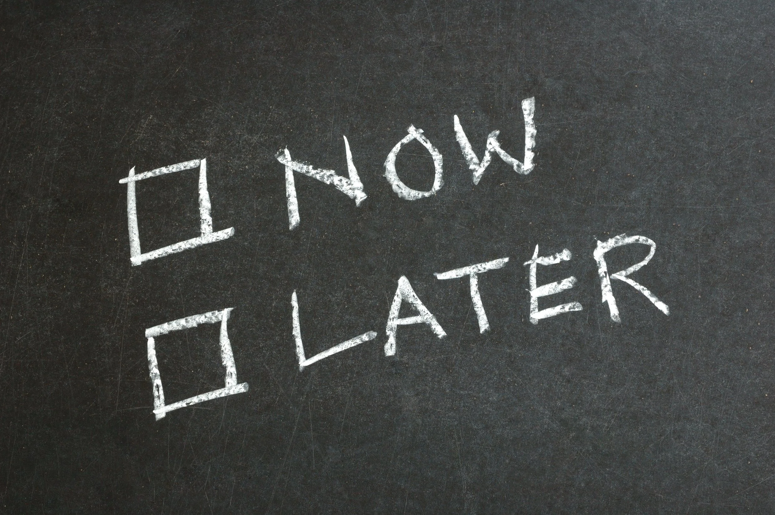 Chalkboard image showing “Now” and “Later,” representing the years of procrastination before Arkeym N. Young began writing.