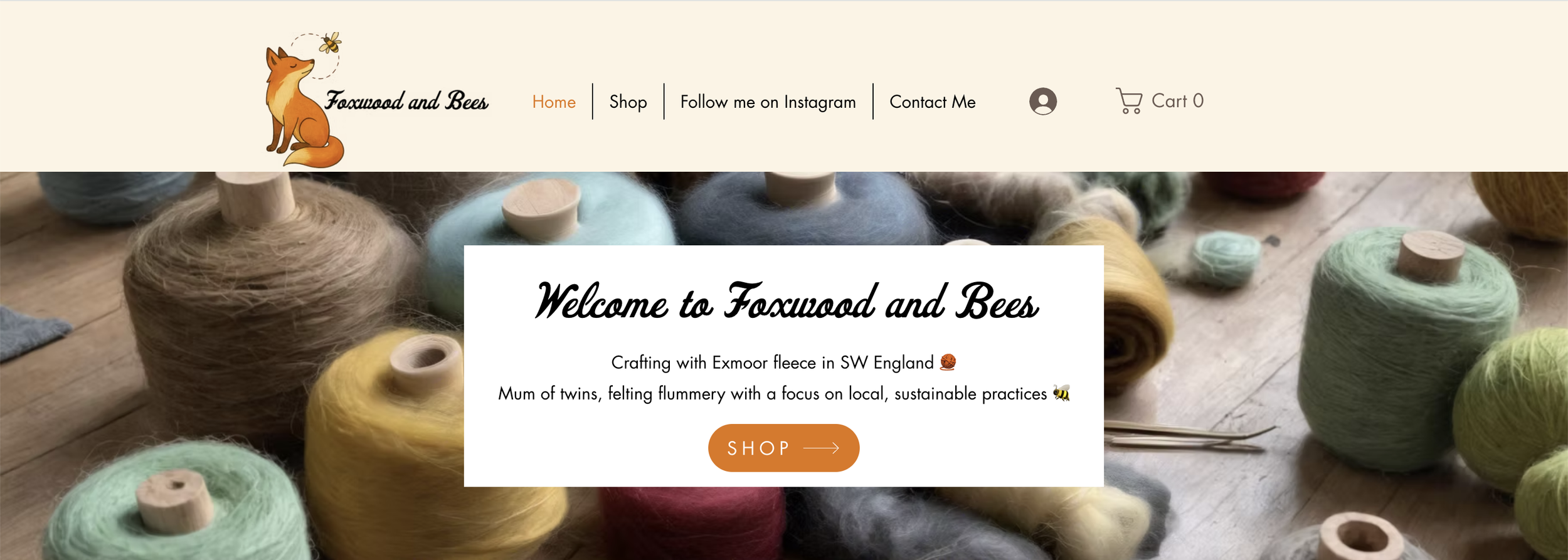 Homepage of Foxwood and Bees website featuring colorful wool yarns on a wooden surface with a welcome message and shop button.