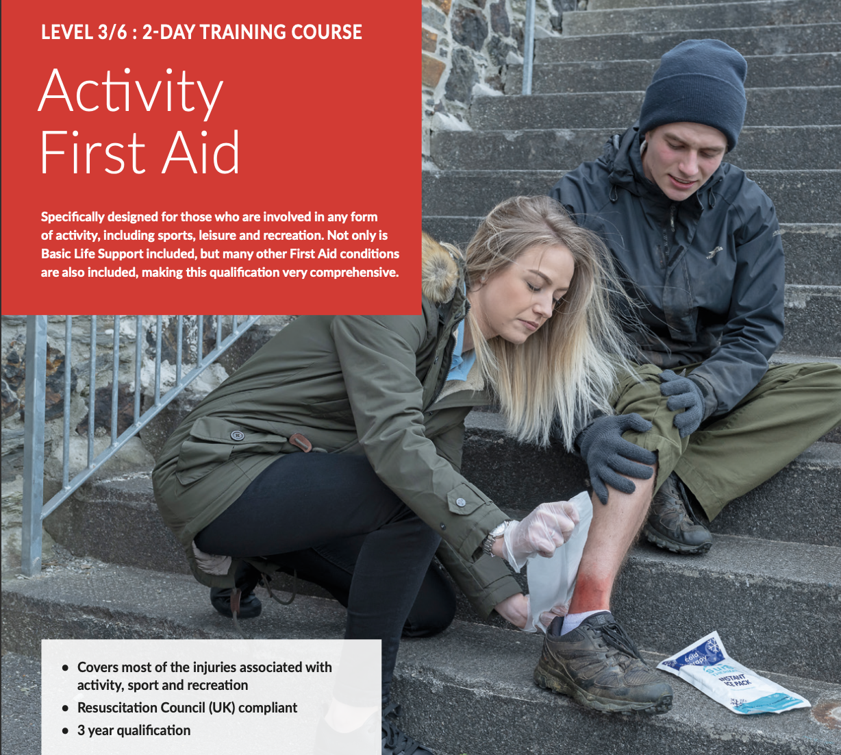 A woman providing first aid to a young man with a leg injury, sitting on outdoor stairs with a cold pack, while holding his foot. Another person is assisting them, with a bag of ice nearby.