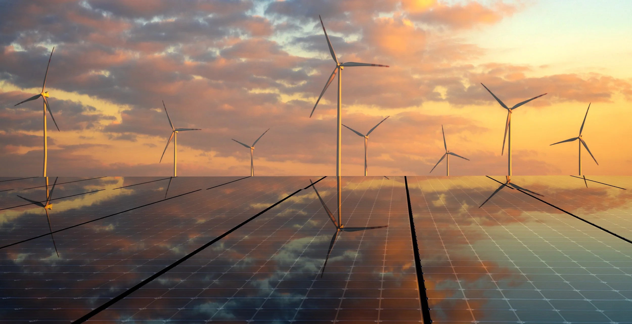 Wind turbines and solar panels at sunset or sunrise.