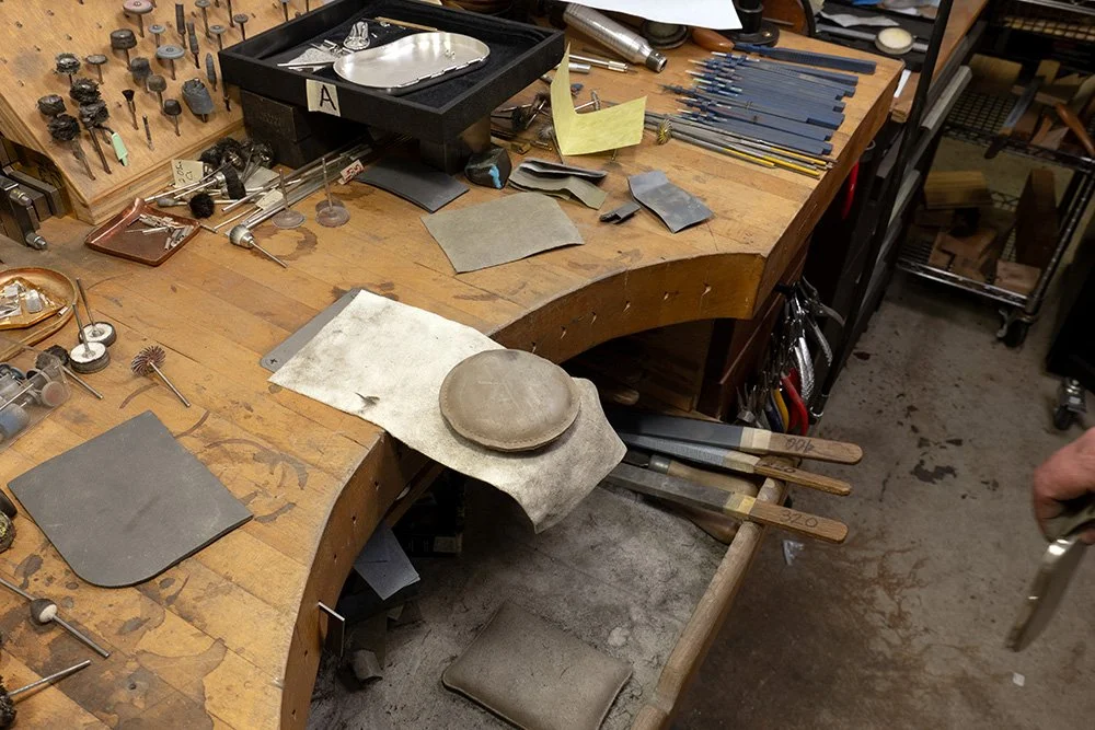 A metalsmith workbench of a Et. Collective team member, featuring tools and parts.