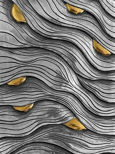 Close-up of layered silver detail with scattered gold accents and organic shapes.