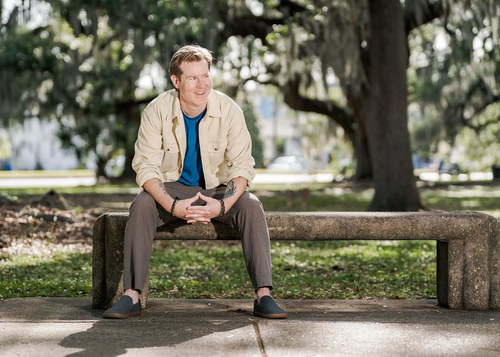 Headshot of Therapist Powell Burke sitting on park bench in park