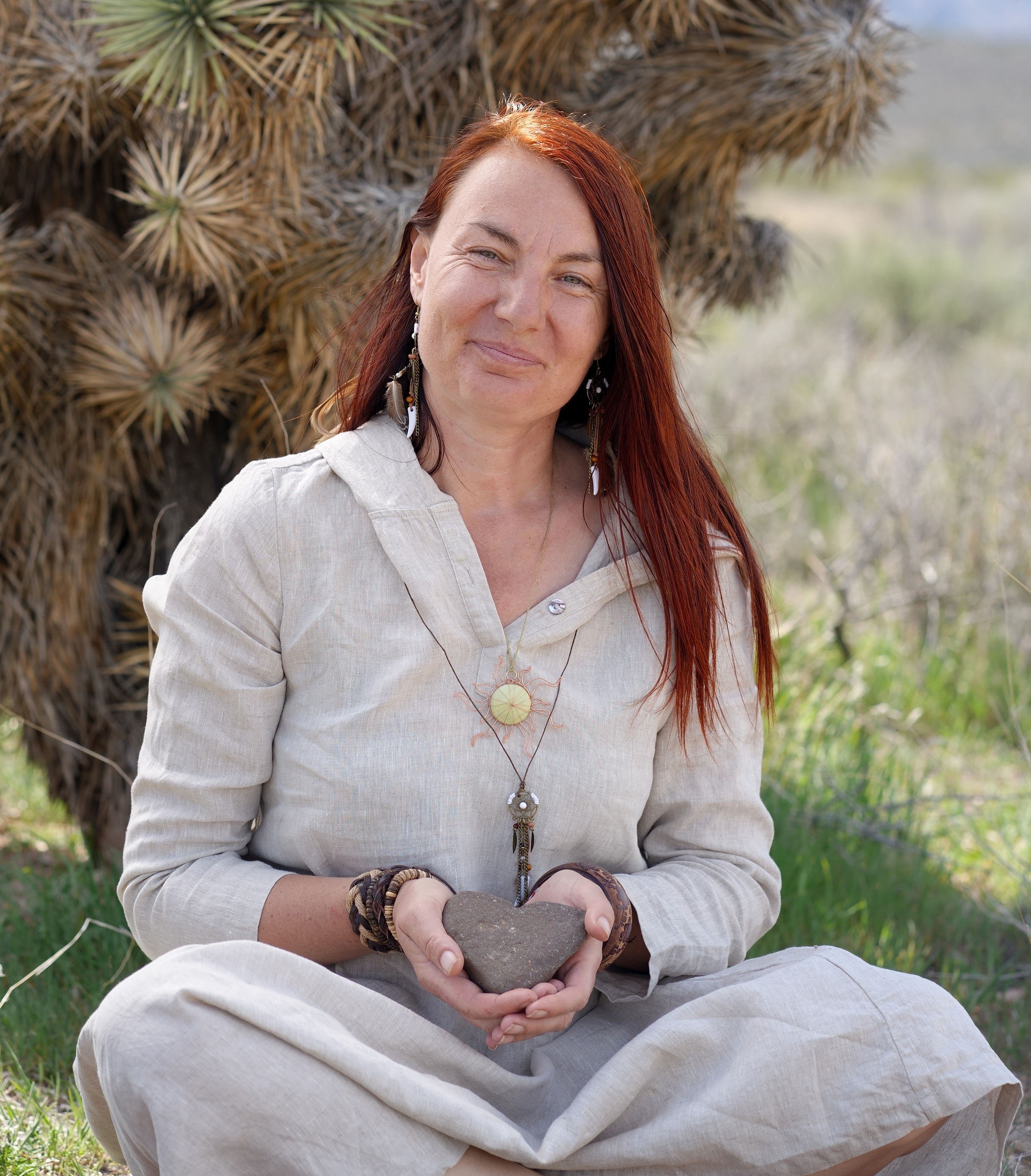 Silviya Doneva, founder of The Butterfly Alchemy, holding a heart-shaped stone in the Arizona desert