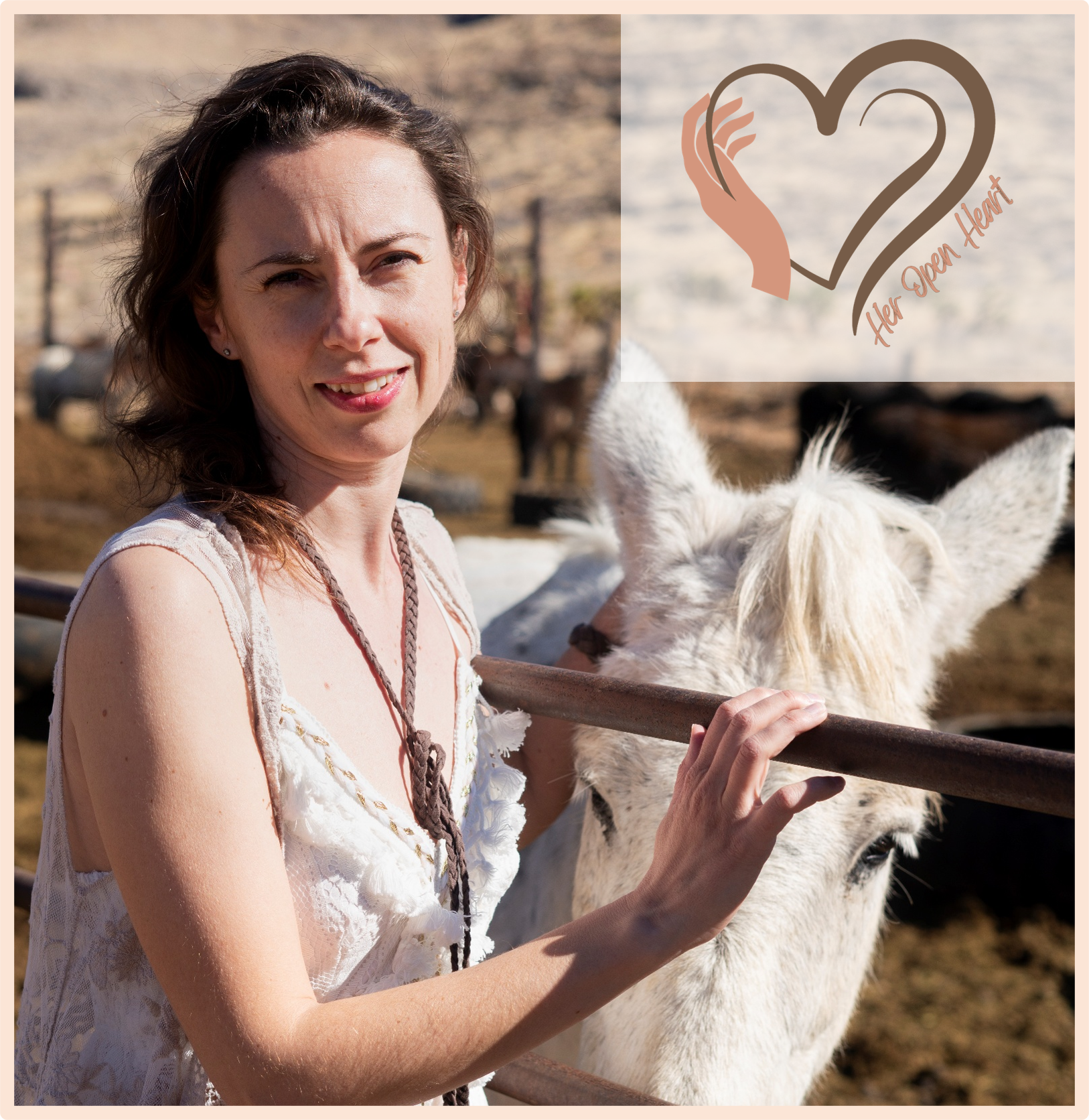 A woman with brown hair and a sleeveless white lace dress standing next to a white donkey at an outdoor farm, with a logo in the top right corner featuring a heart shape and the text 'Her Open Heart'.