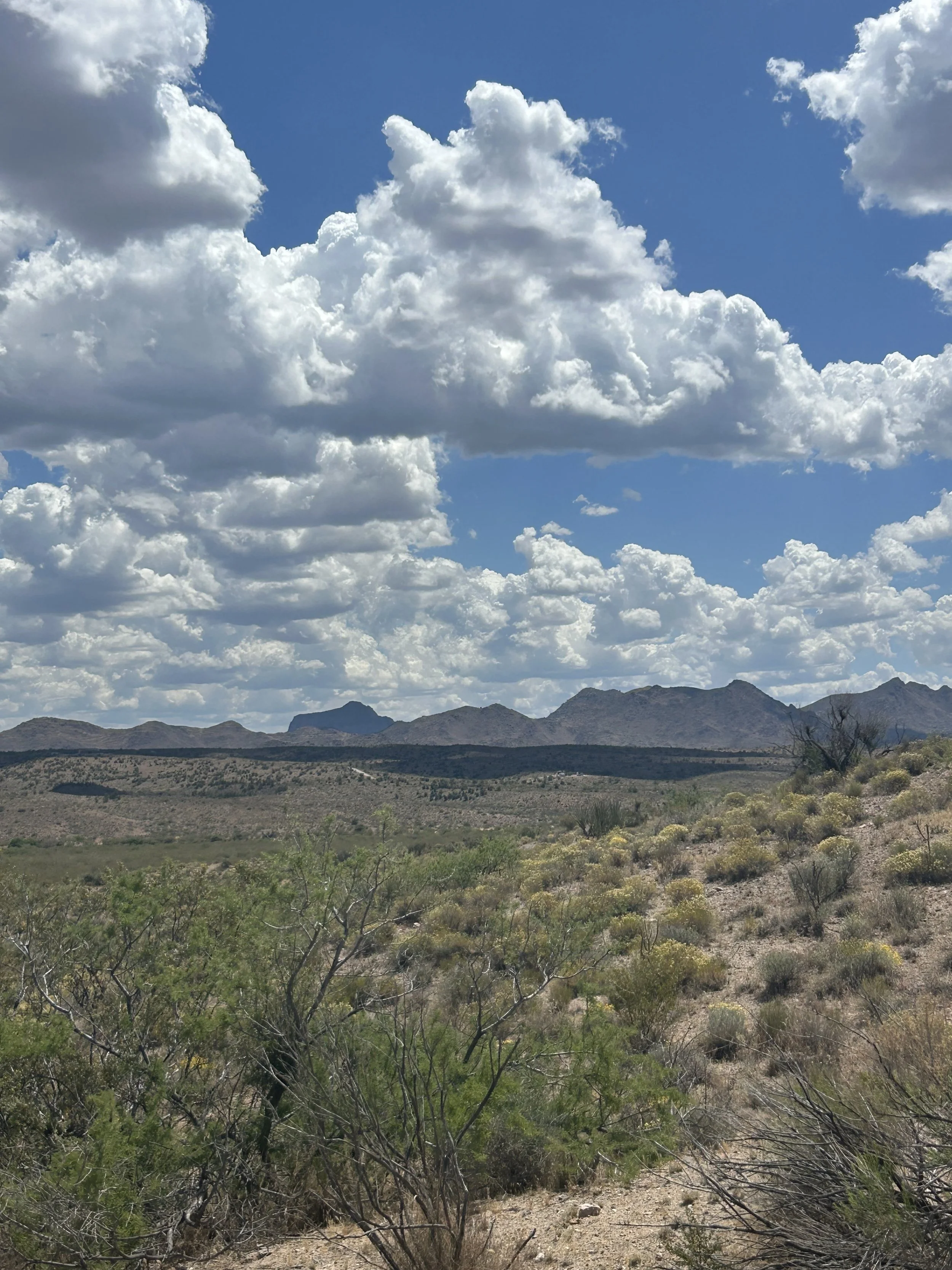 Dramatic clouds over the mountains and open desert landscape near the Arizona retreat.