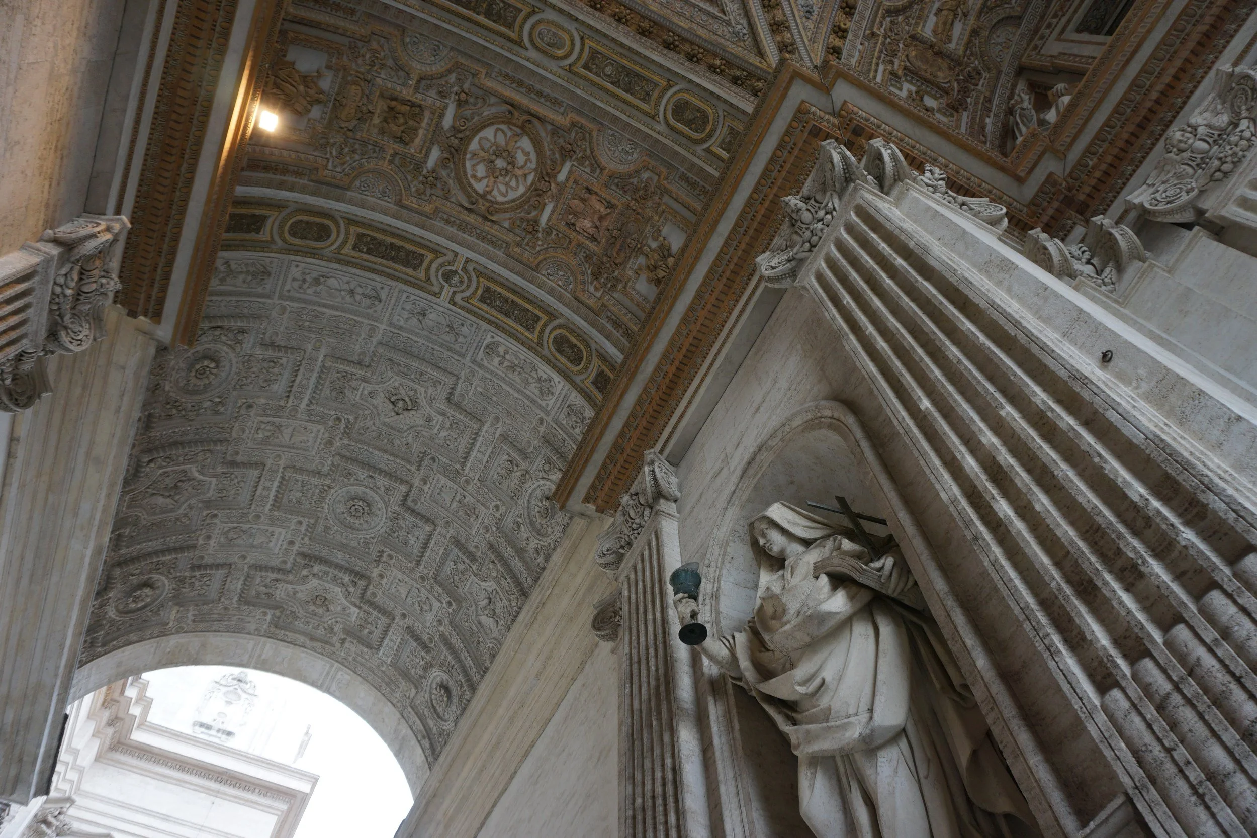 Decorative archway with detailed sculptures and ornate carvings on the ceiling.