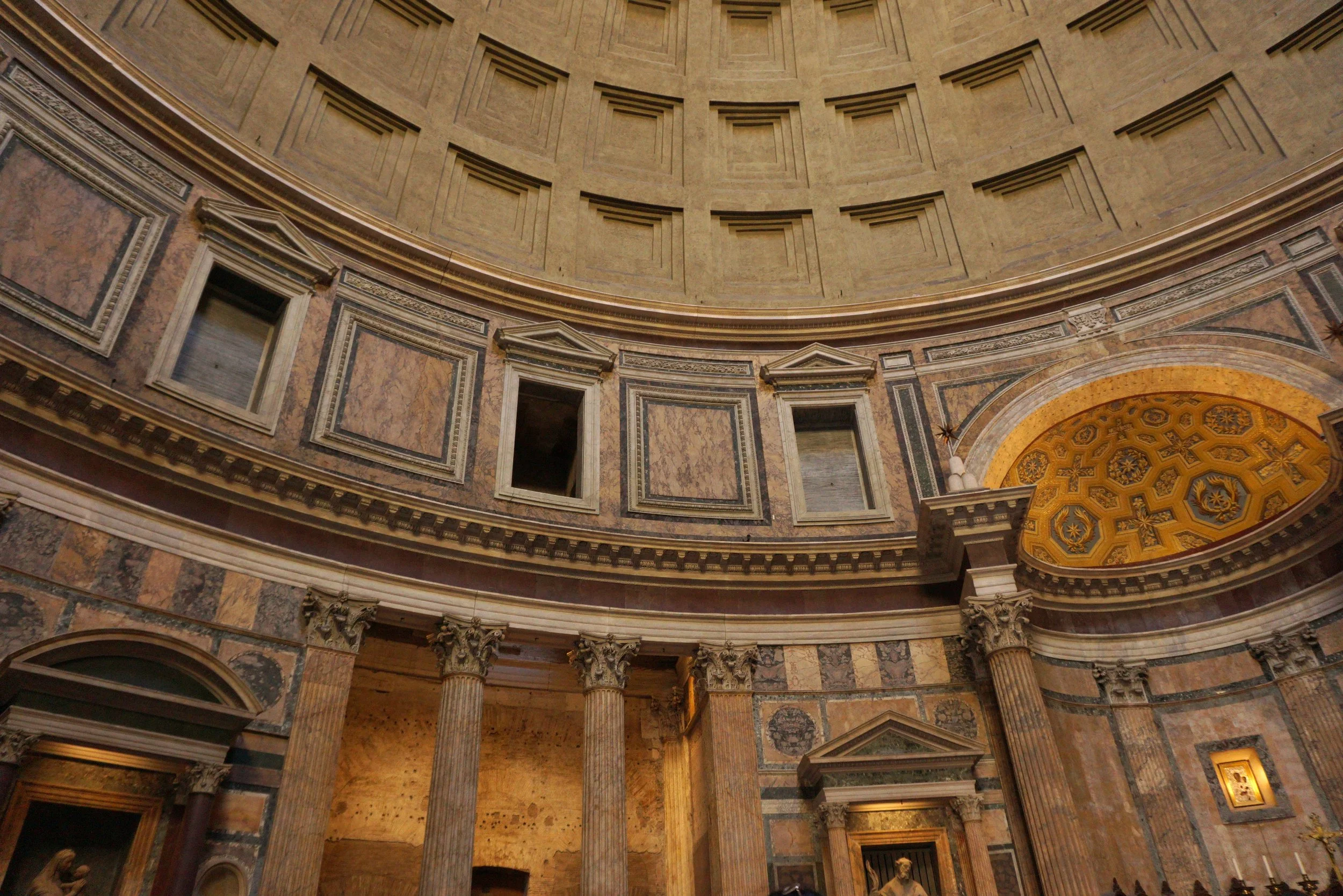 Interior of a historic building featuring a domed ceiling, classical columns, and ornate architectural details.