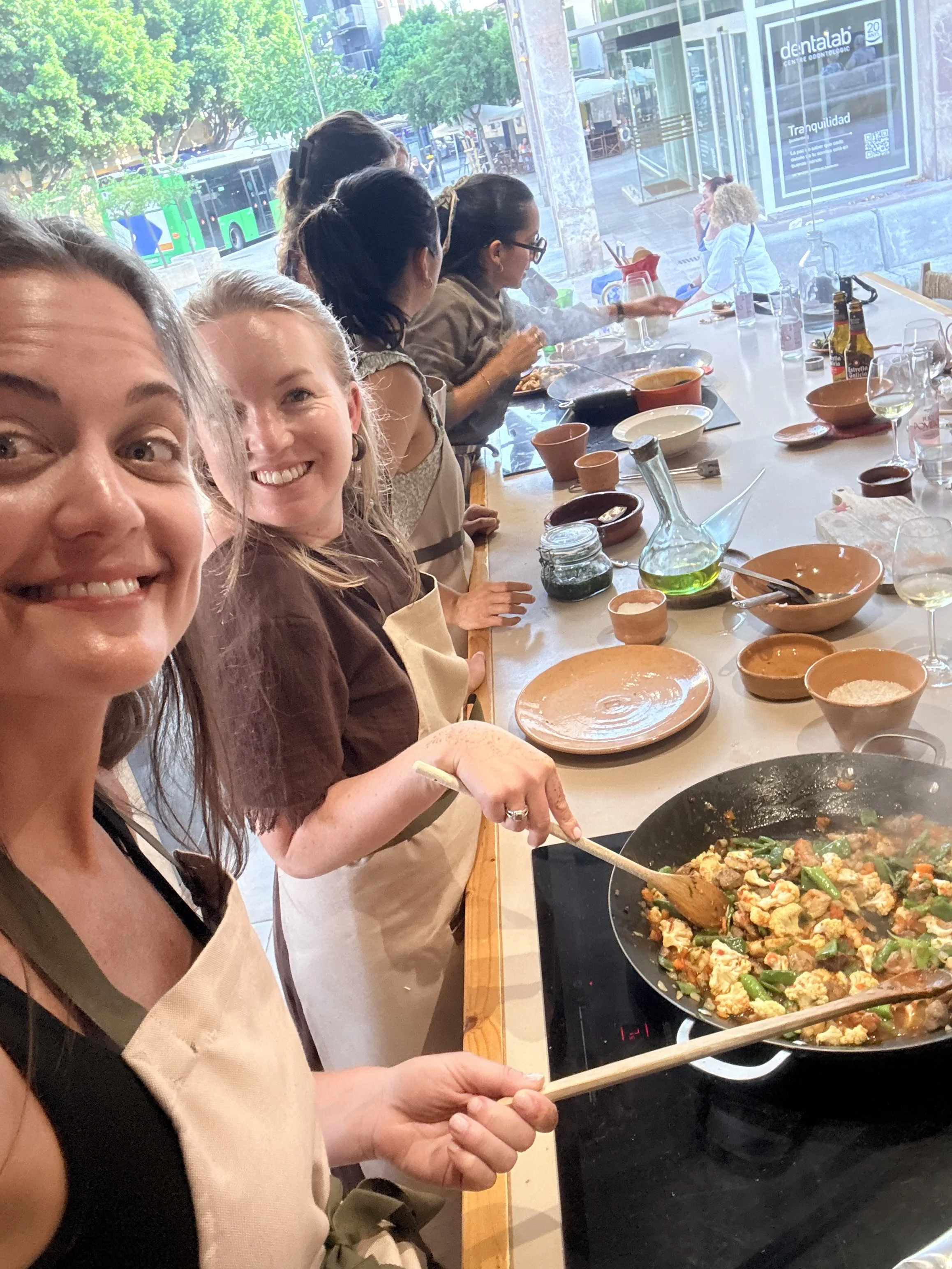 Meghan and Michele cooking together during a hands-on culinary class in Mallorca.