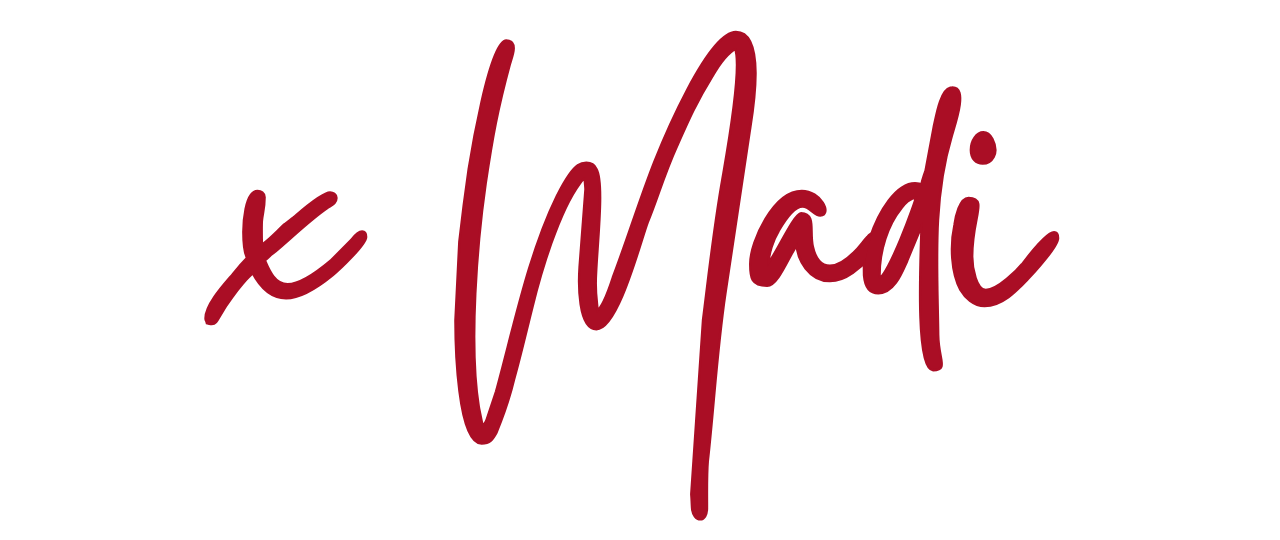 Handwritten text saying 'X Madi' in maroon ink on a transparent background.