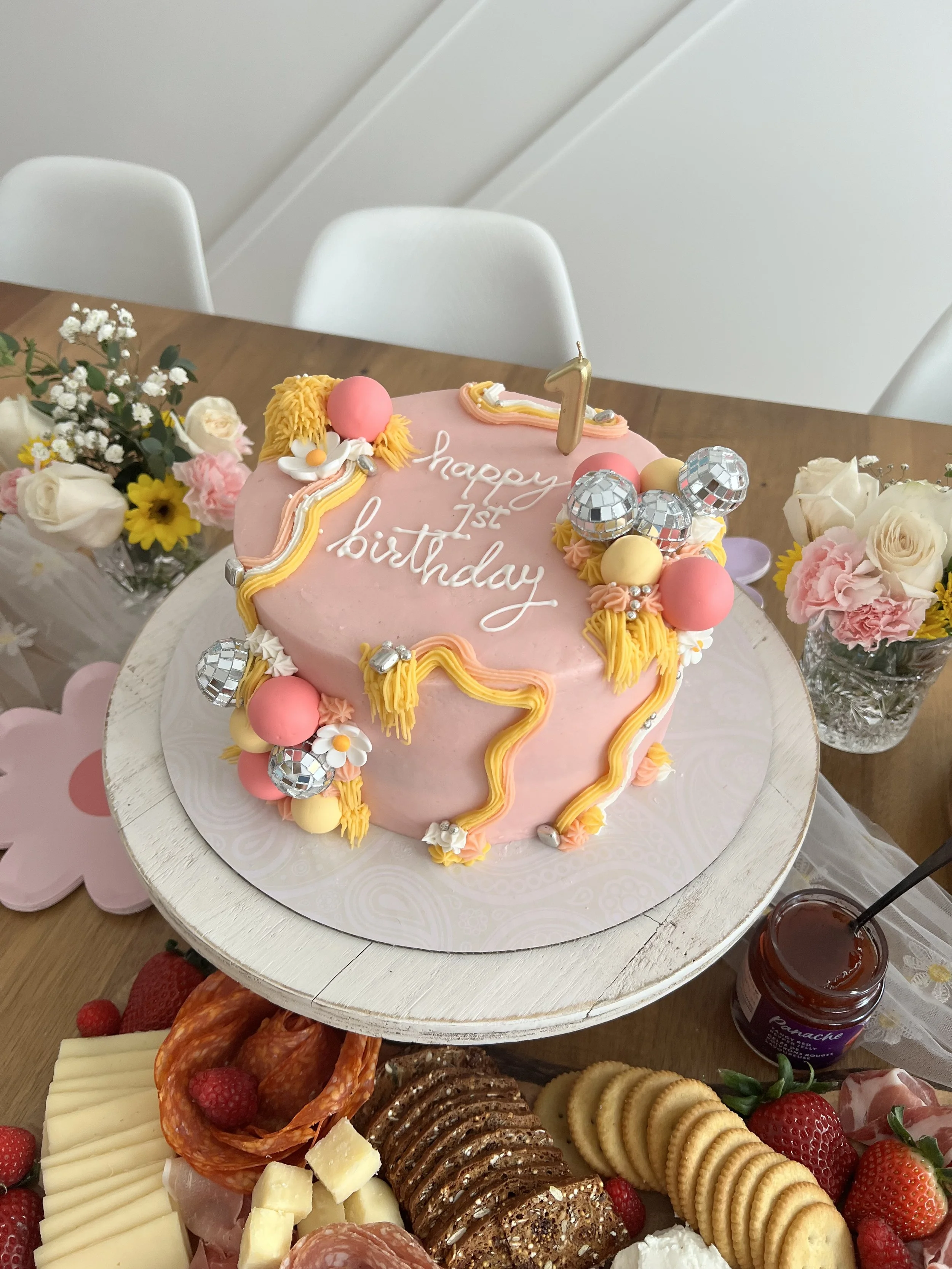 A pink birthday cake with white writing that says 