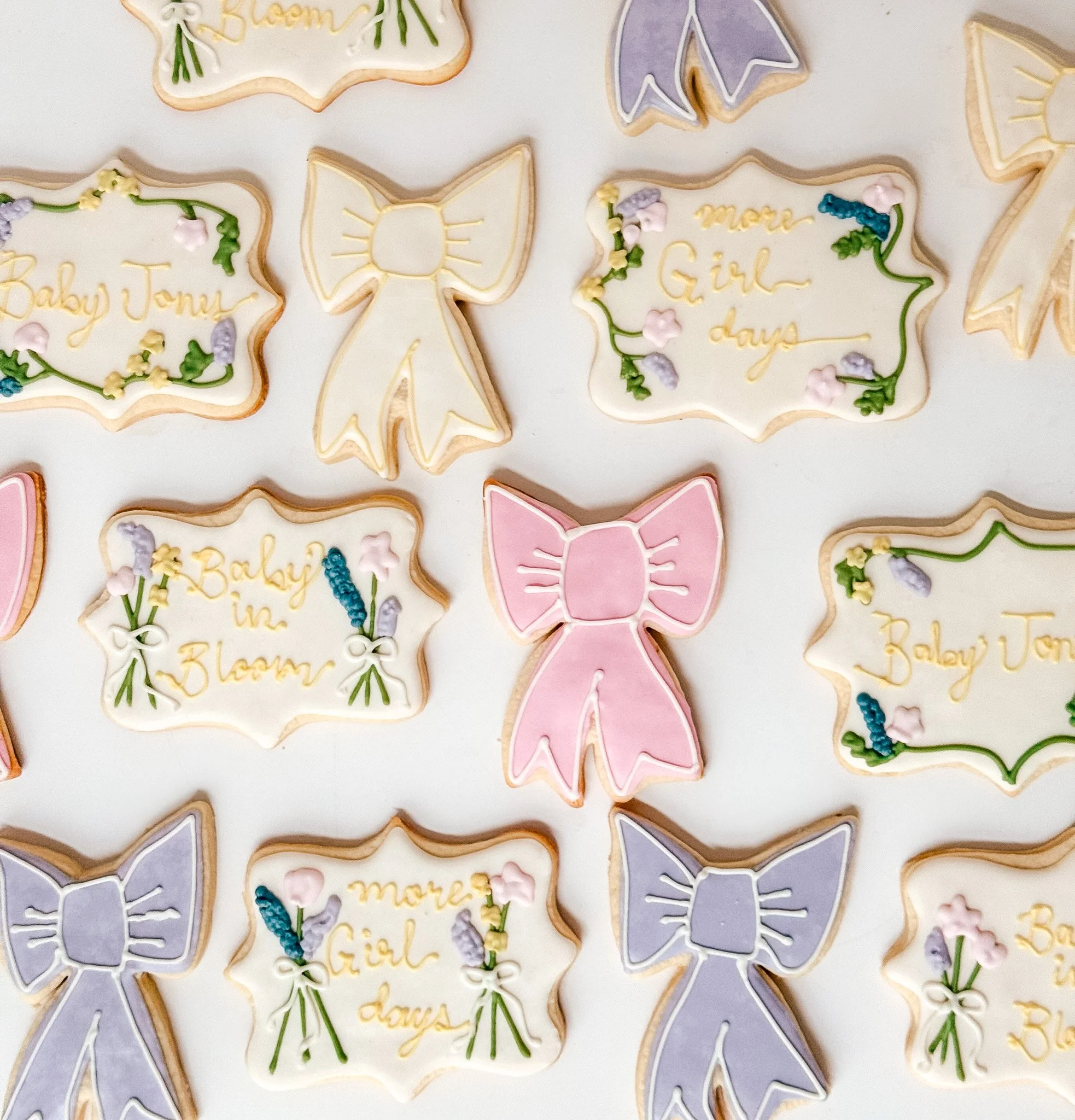 Decorated cookies with spring-themed designs, including rabbits, flowers, and messages like 'more girl' and 'baby toni' written in icing.