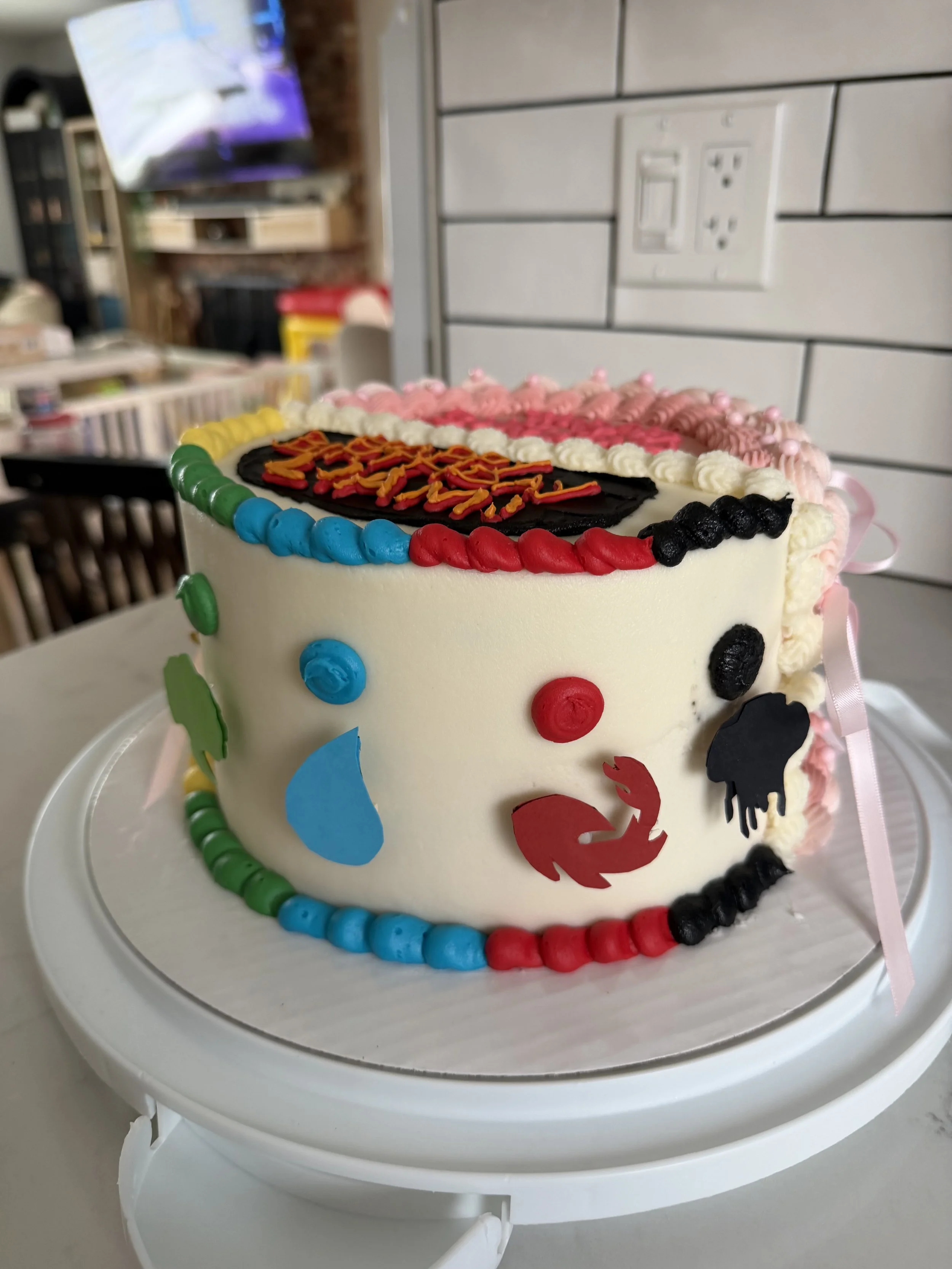 Celebration cake decorated with colorful candies and icing, with a message written on top.