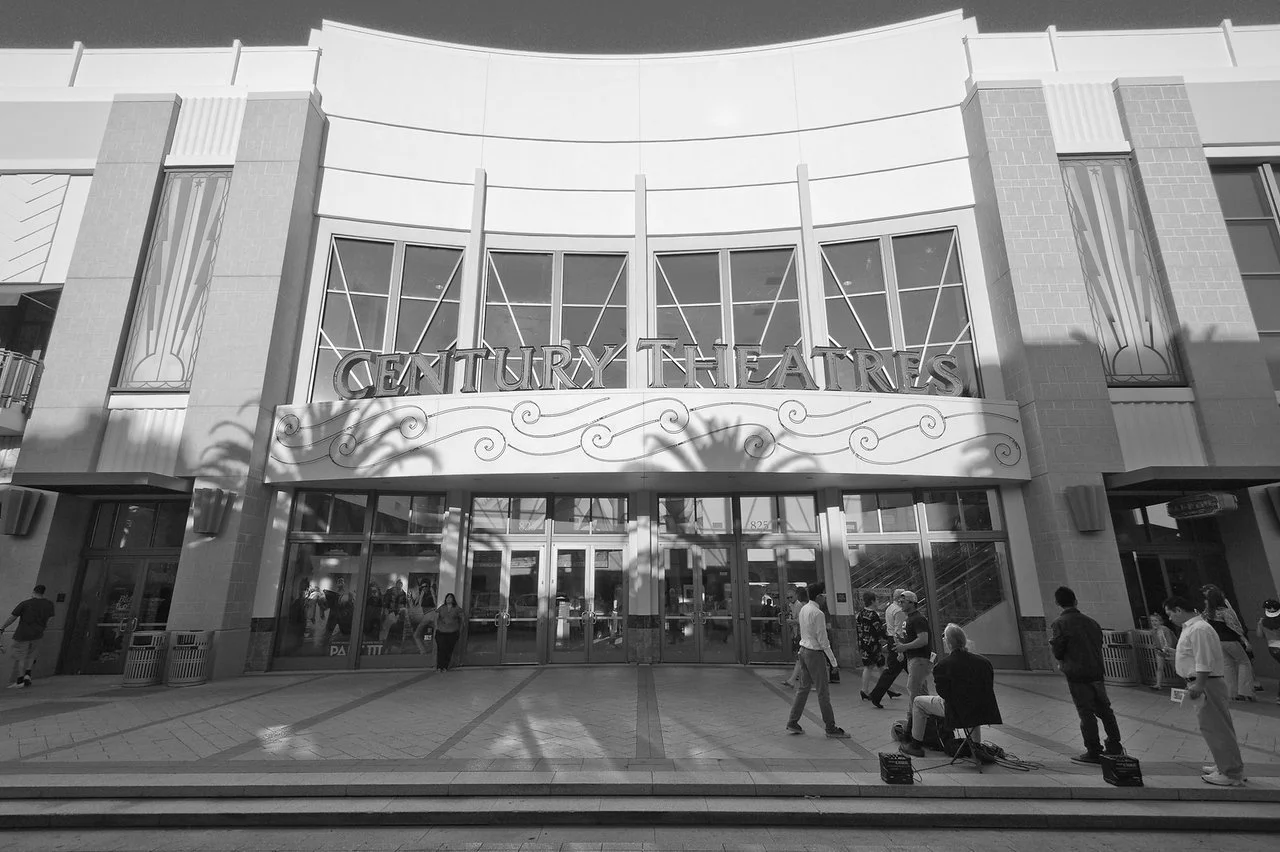 People entering and exiting the Century Theatres movie theater building.