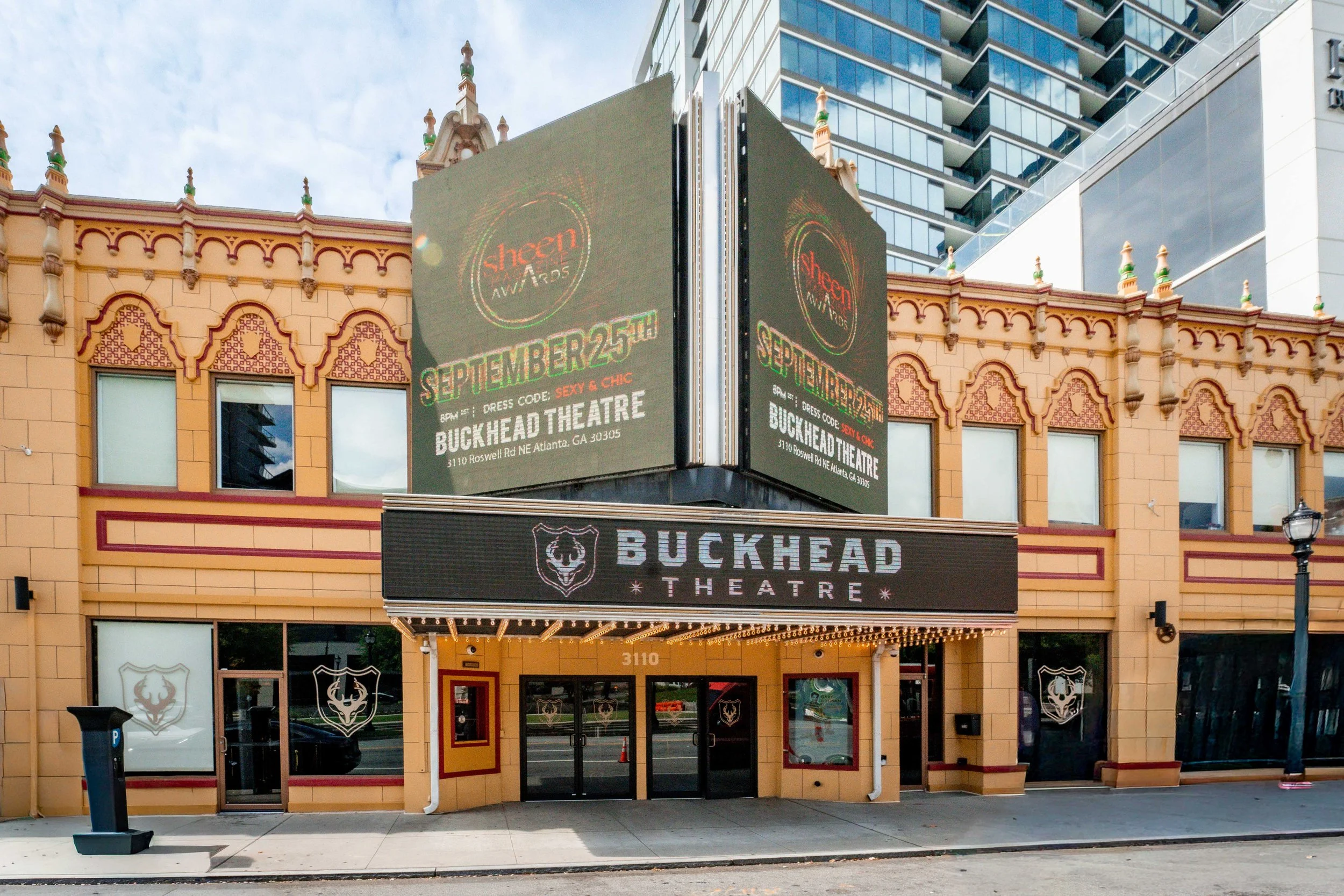 Exterior of Buckhead Theatre in Atlanta, Georgia, with illuminated marquee and electronic signs advertising an event on September 25th with dress code 'Sexy & Chic'.