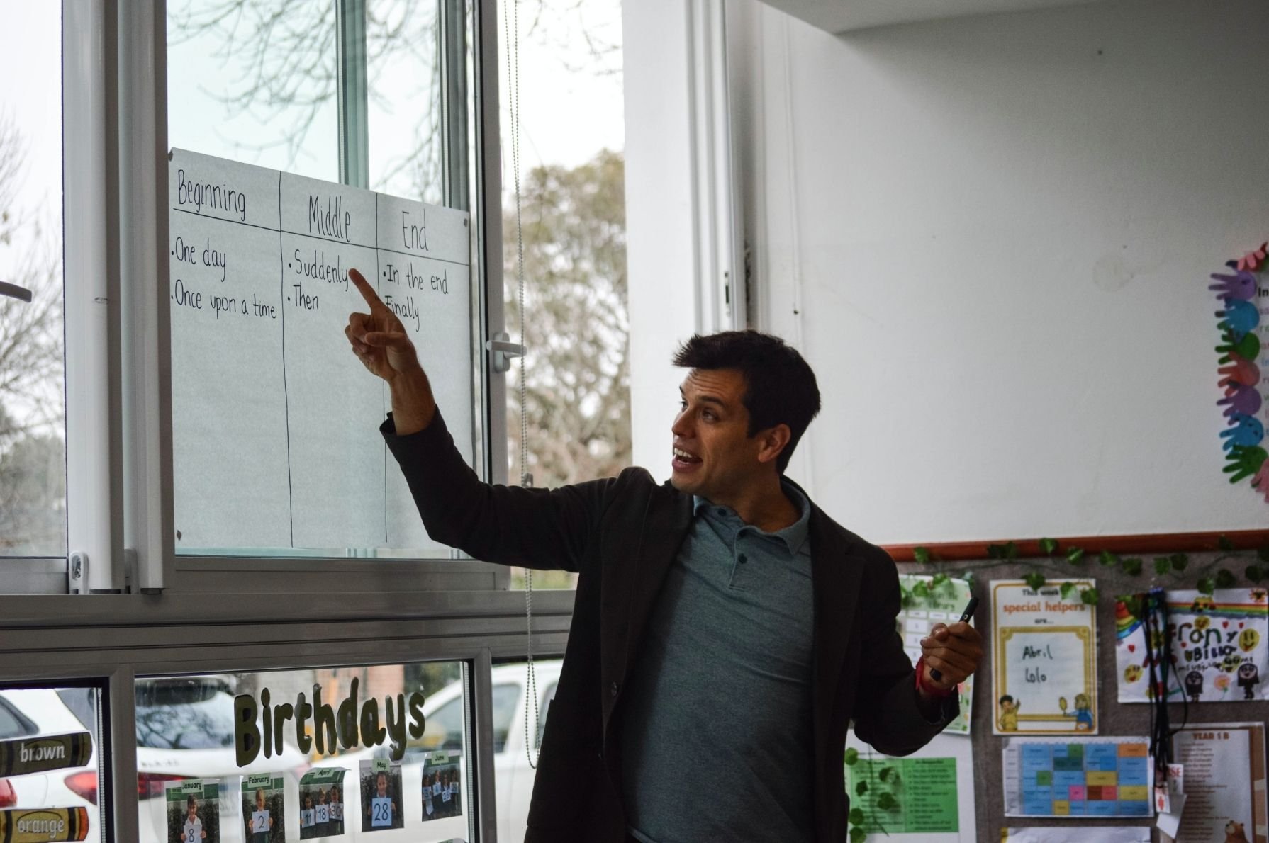 Gerrit Jones-Rooy points to a classroom chart showing the beginning, middle, and end of a story.