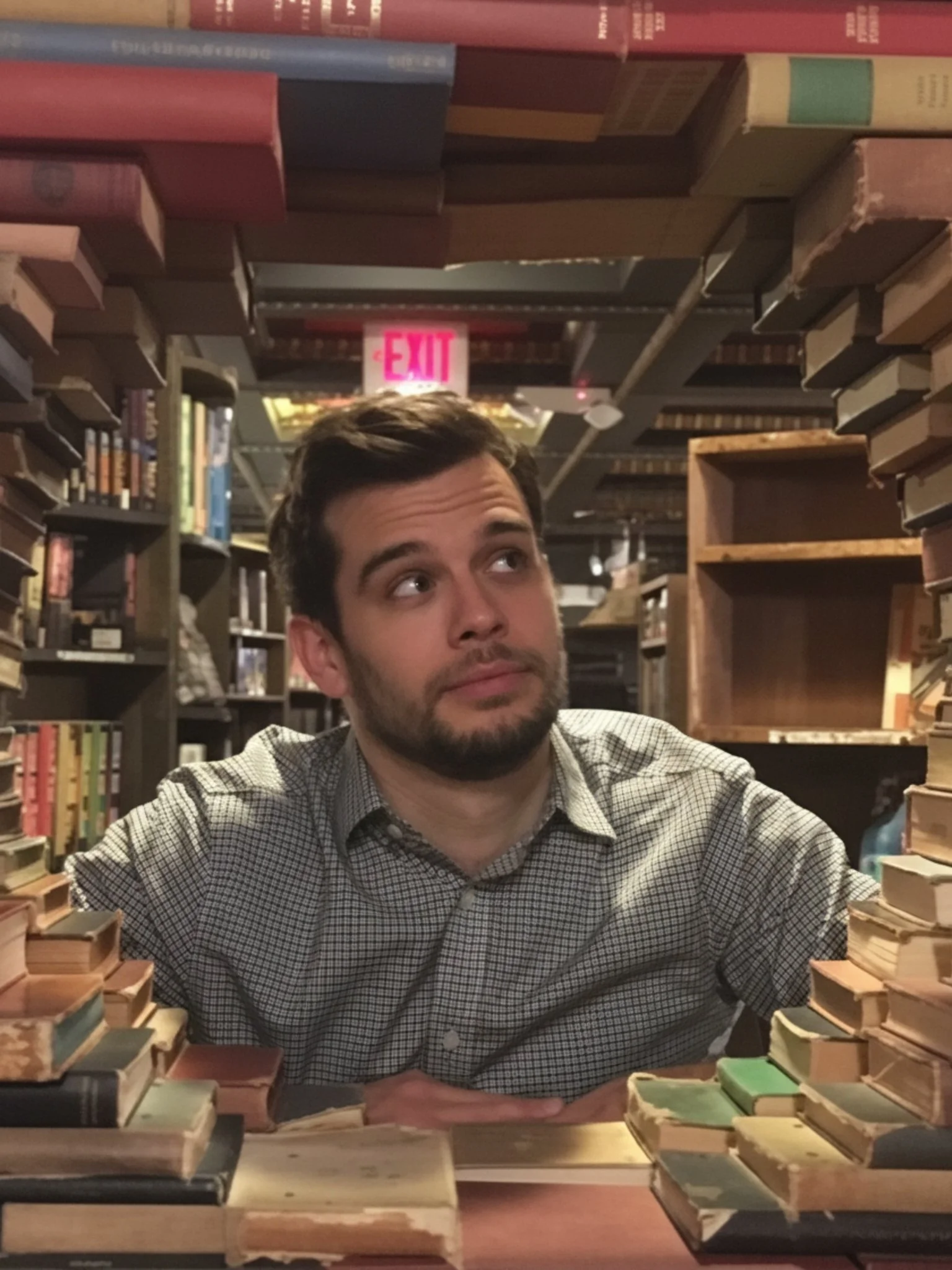 Gerrit Jones-Rooy sits among stacks of books at The Last Bookstore in Los Angeles.