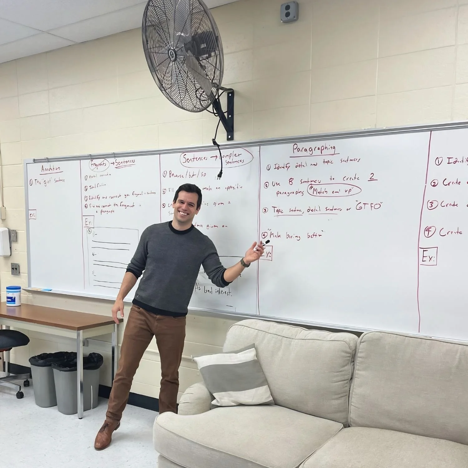 Gerrit Jones-Rooy explains a writing lesson beside a classroom whiteboard.