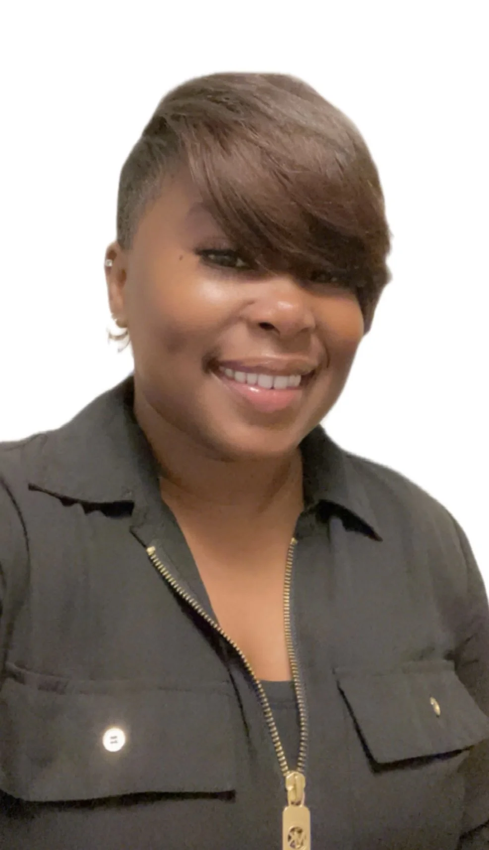 Portrait of a woman with short, styled hair, smiling, wearing a black shirt with a zipper, against a white background.