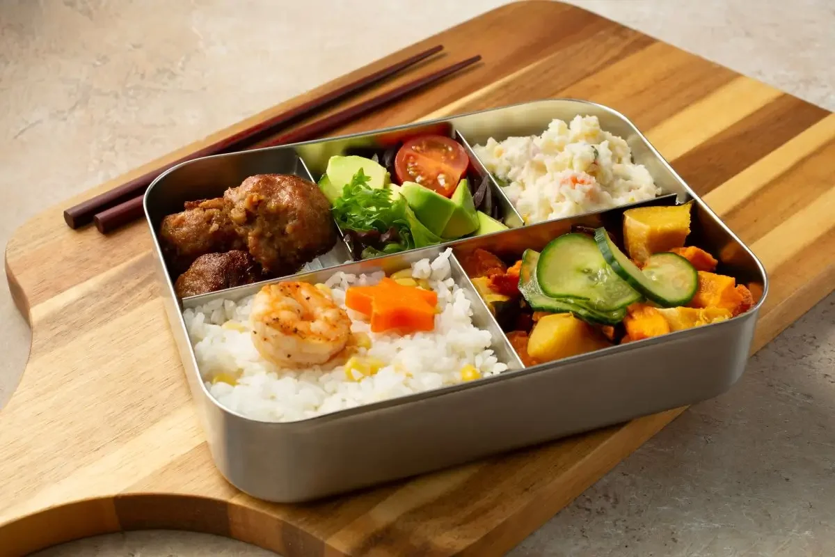 A metal bento box with food.
