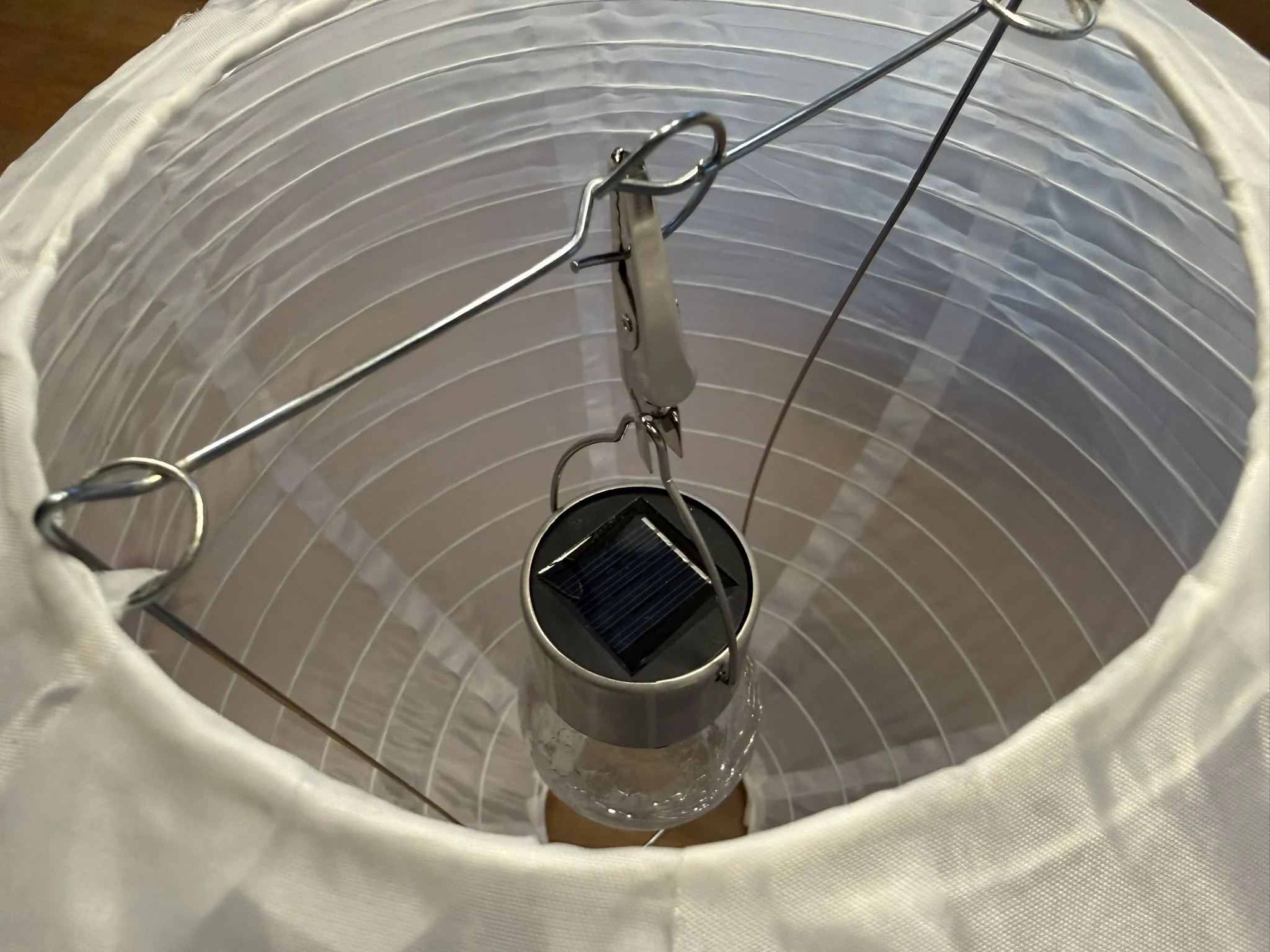 A latex globe lantern with a solar-powered bulb hanging inside.