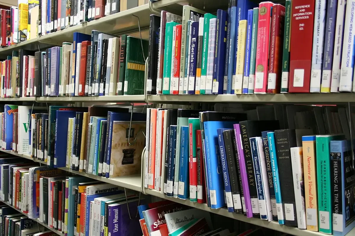 Bookshelves filled with various colorful books in a library.