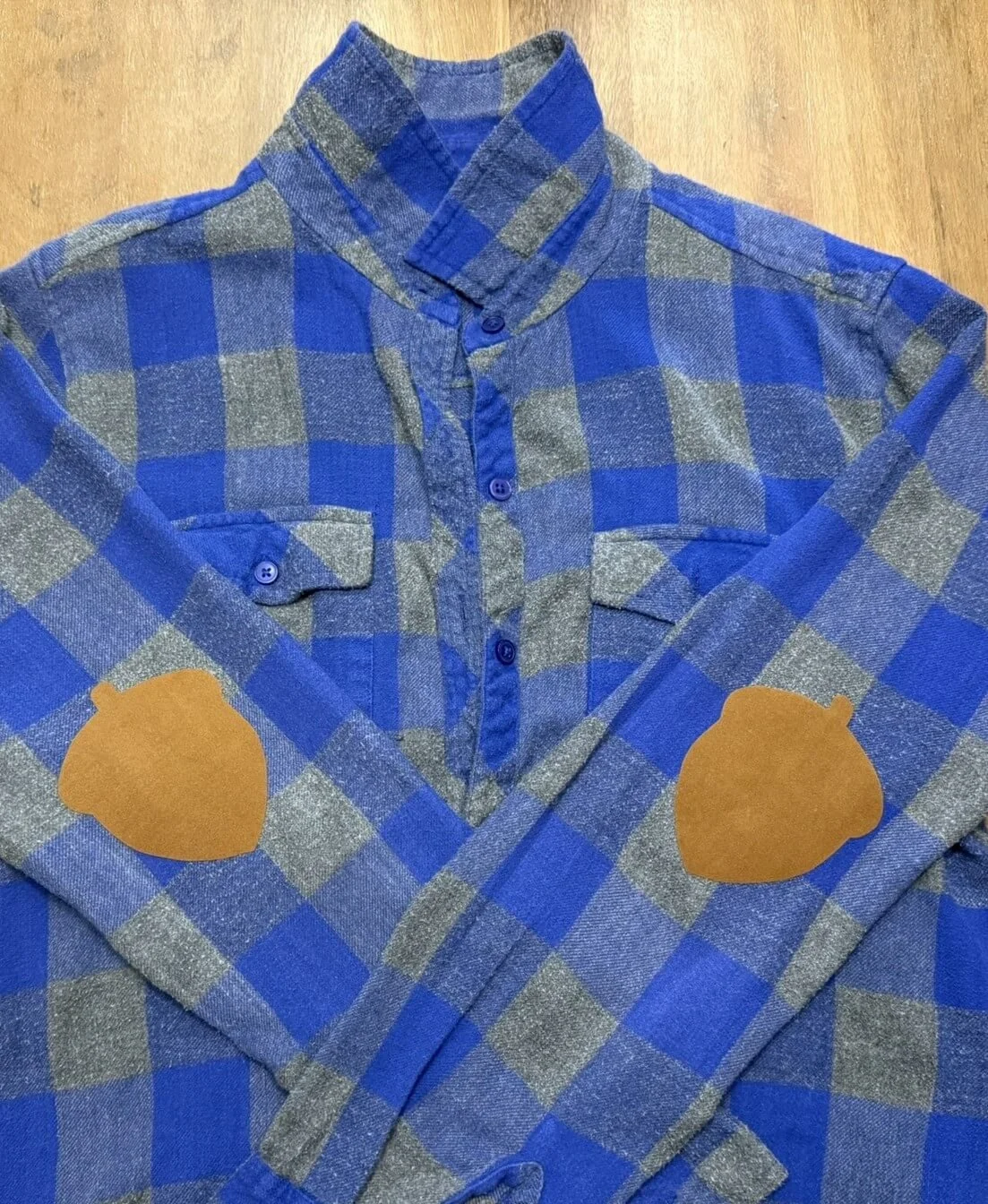 Blue and gray plaid button-up shirt with bear-shaped patches on the elbows.