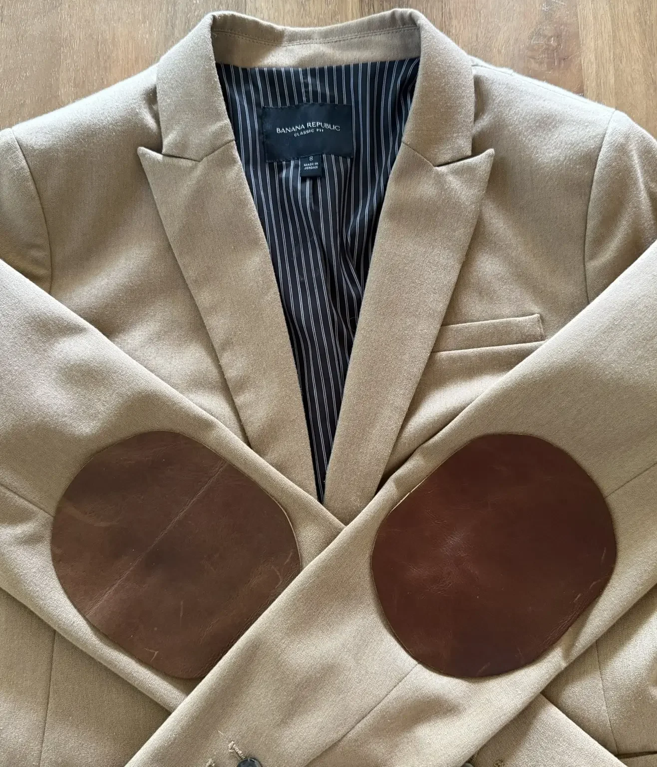 A beige blazer with brown leather elbow patches.