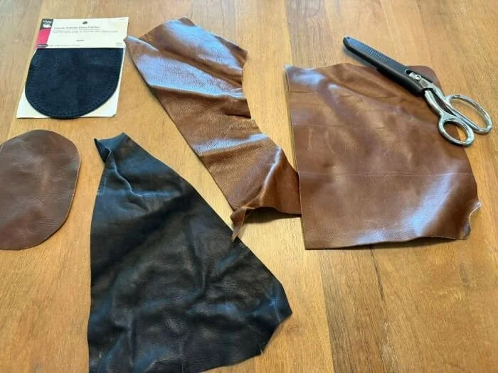 Pieces of leather, cut elbow pads, and a chrome scissors.