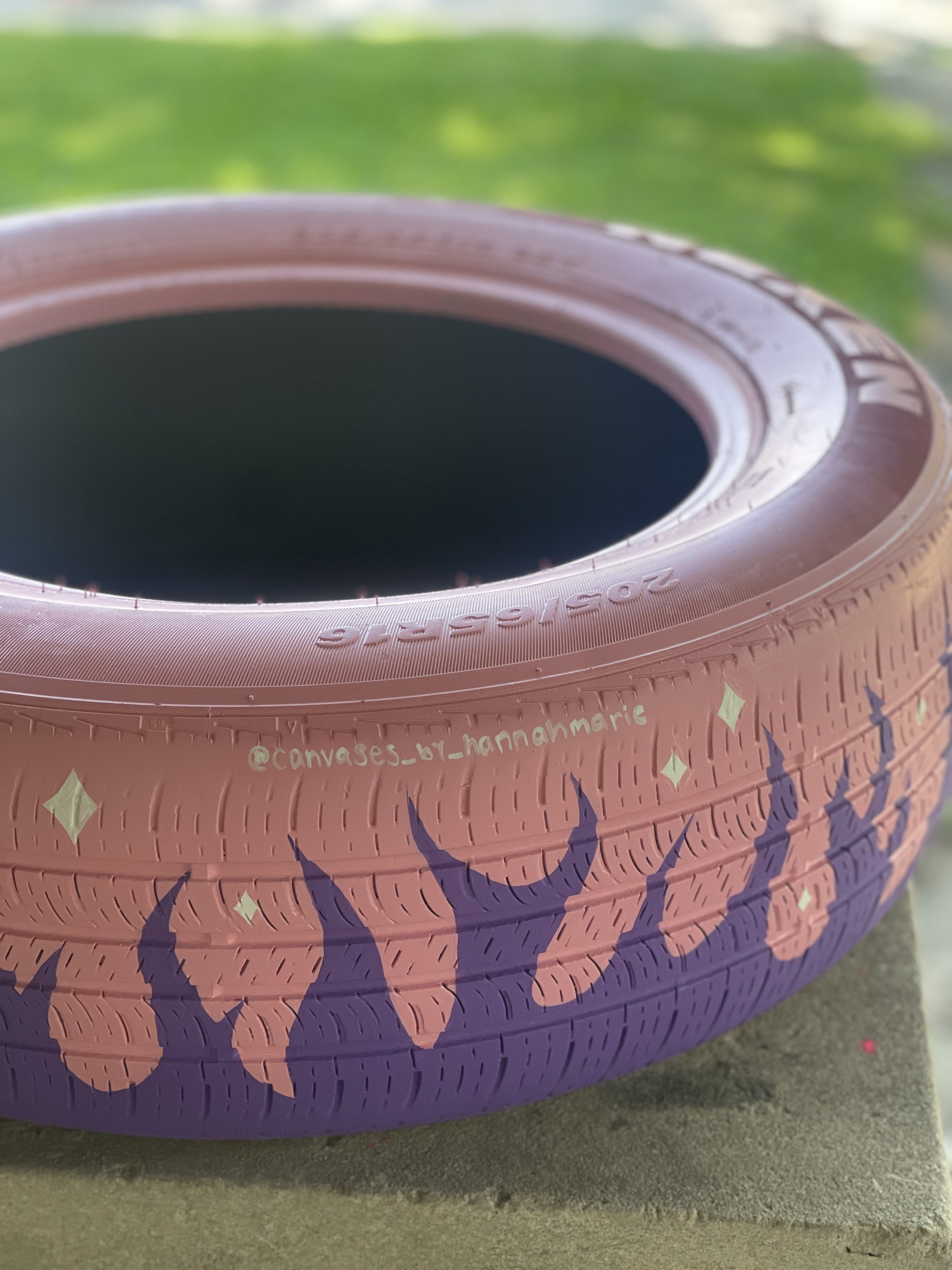 Close-up of a pink and purple tire with decorative patterns, including stars and flames.