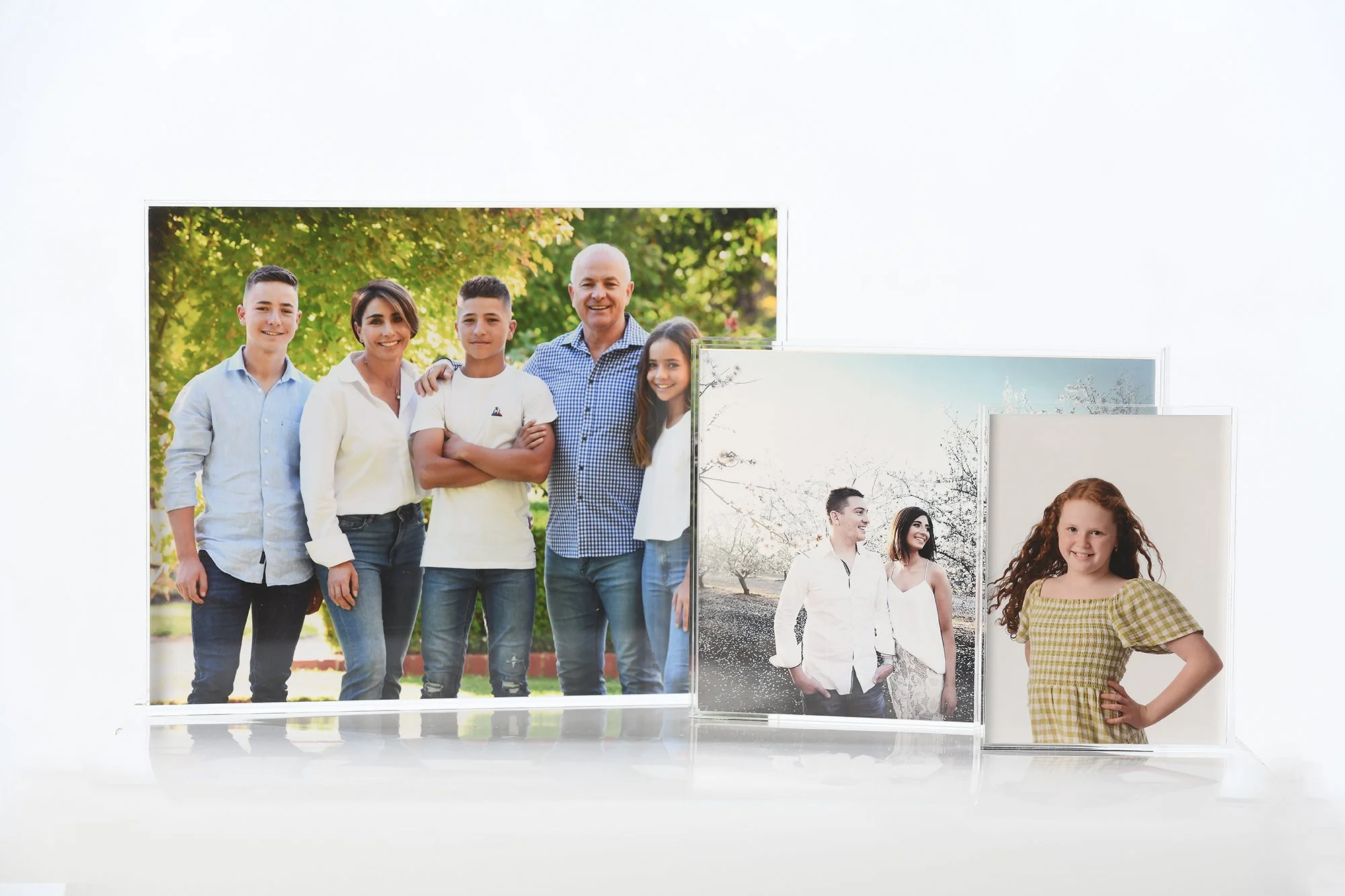 Set of printed photographs including a family portrait outdoors and other images of children and couples.