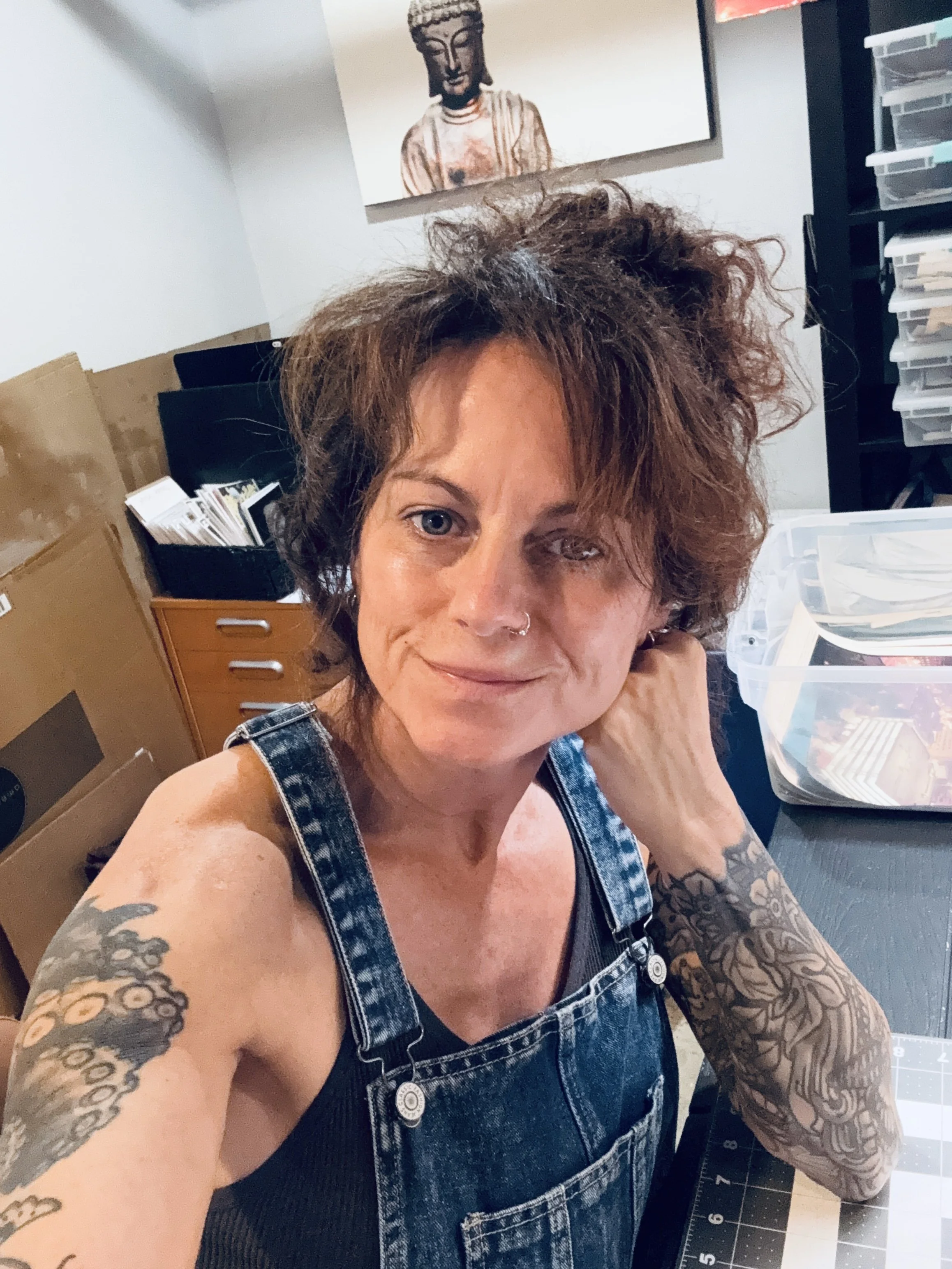 iphone selfie of the artist in her studio, wearing overalls