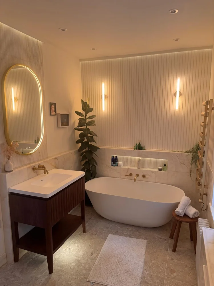 Luxury full bathroom with oval freestanding bath, fluted wall panels and warm ambient lighting — bathroom installation Nottingham