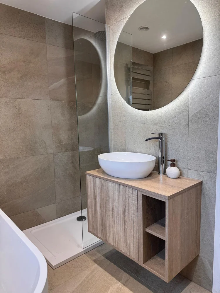 Stone-effect tiled bathroom with oak vanity unit and round LED backlit mirror — bathroom installation Nottingham